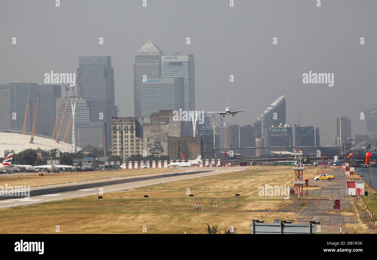 British Airways-Passagier-Jet landet auf dem Flughafen London City. Canary Wharf und den Millennium Dome im Hintergrund Stockfoto