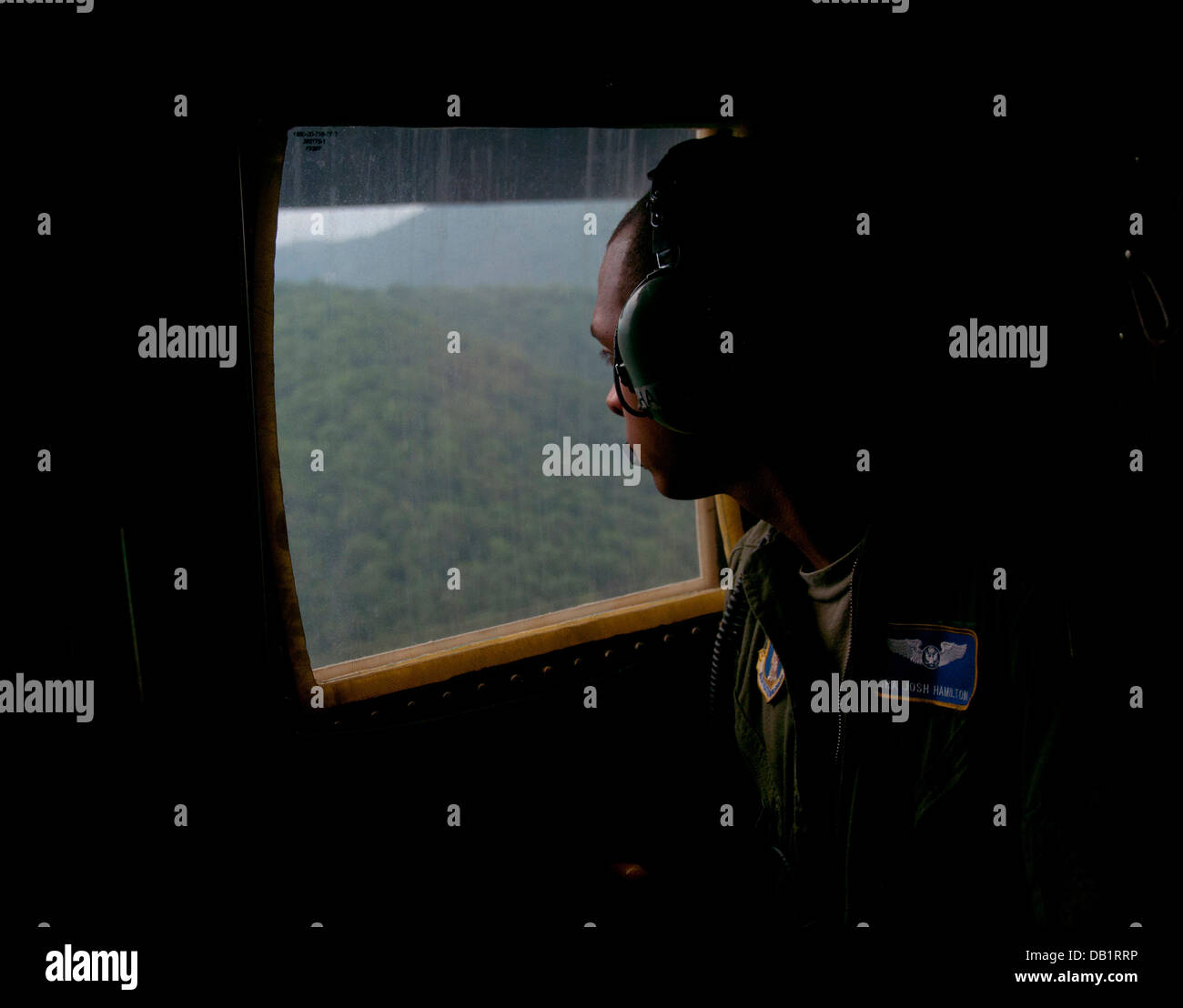 Senior Airman Josh Hamilton ein Loadmaster mit dem 130. Airlift Wing, Charleston, W.VA beobachtet die Drop-Zone-Gelände aus dem Fenster einer c-130 während Fortbildungsveranstaltung Sentry Sturm, 18. Juli 2013, über Camp Zweig Logan County, W. VA. 130. Luftbrücke Stockfoto