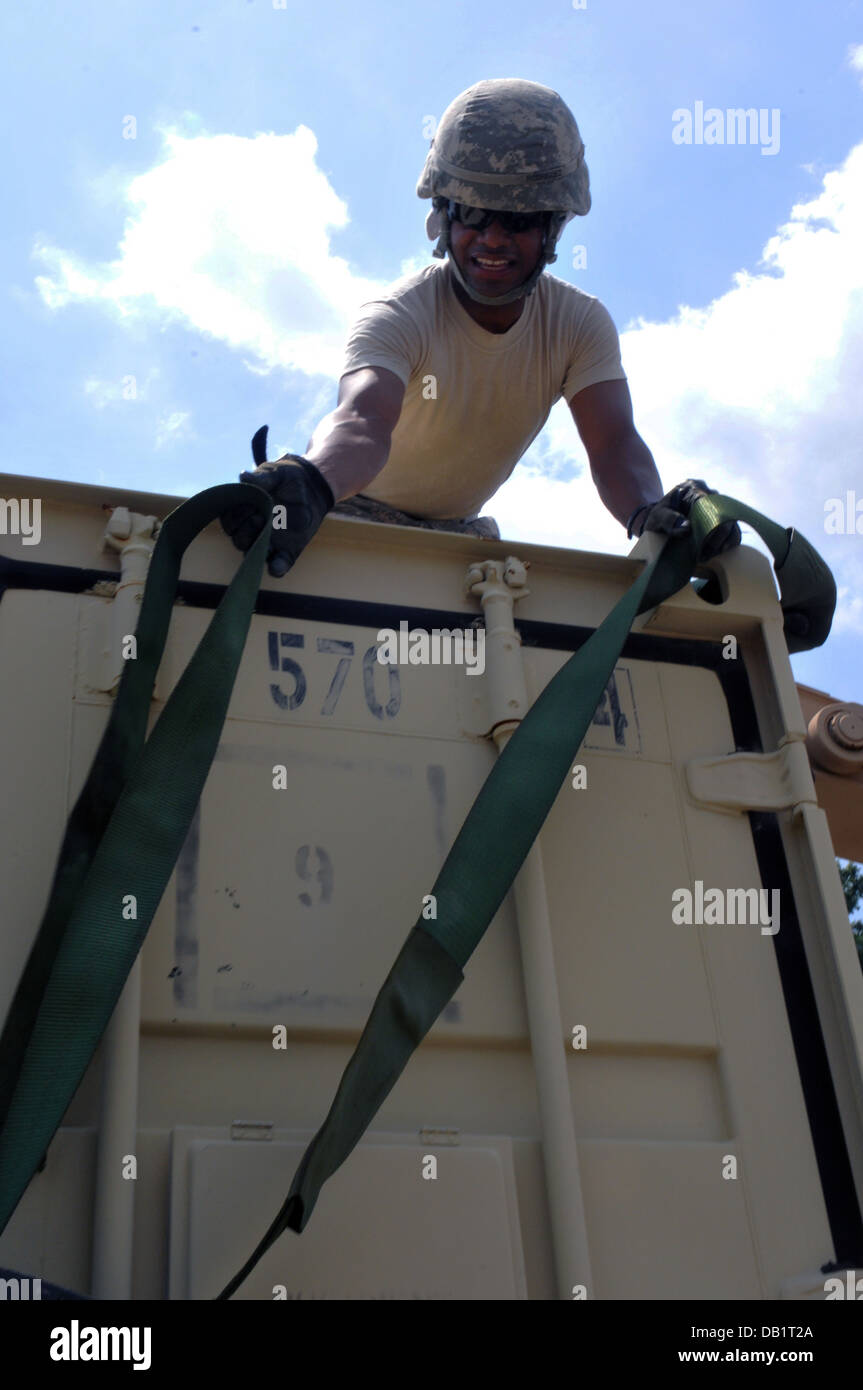 SPC. Cornelio Rodriguez, ein Transport-Spezialist mit 126. Transportation Company, 189. bekämpfen Sustainment Support Battalion und Puerto Rico stammende Riemen unten ein Tri-Con während eine Unterstützungsmission in Fort Lee, VA., 16 Juli. Stockfoto