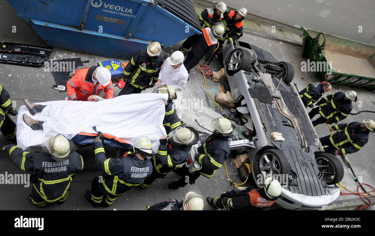 Feuerwehrleute arbeiten auf dem Gelände des Unfalls wo das Auto od eine Frau ist nach einem Sturz 10 Meter von einem Parkplatz in Hamburg, Deutschland, 14. September 2011 gelandet. Die 66-jährige Fahrerin hatte durch eine 80 Zentimeter hohe Betonwand stürzte und wurde schwer verletzt. Die Polizei weiß nicht, aber was hatte den Unfall verursacht. Foto: CHRISTIAN TIMMANN Stockfoto