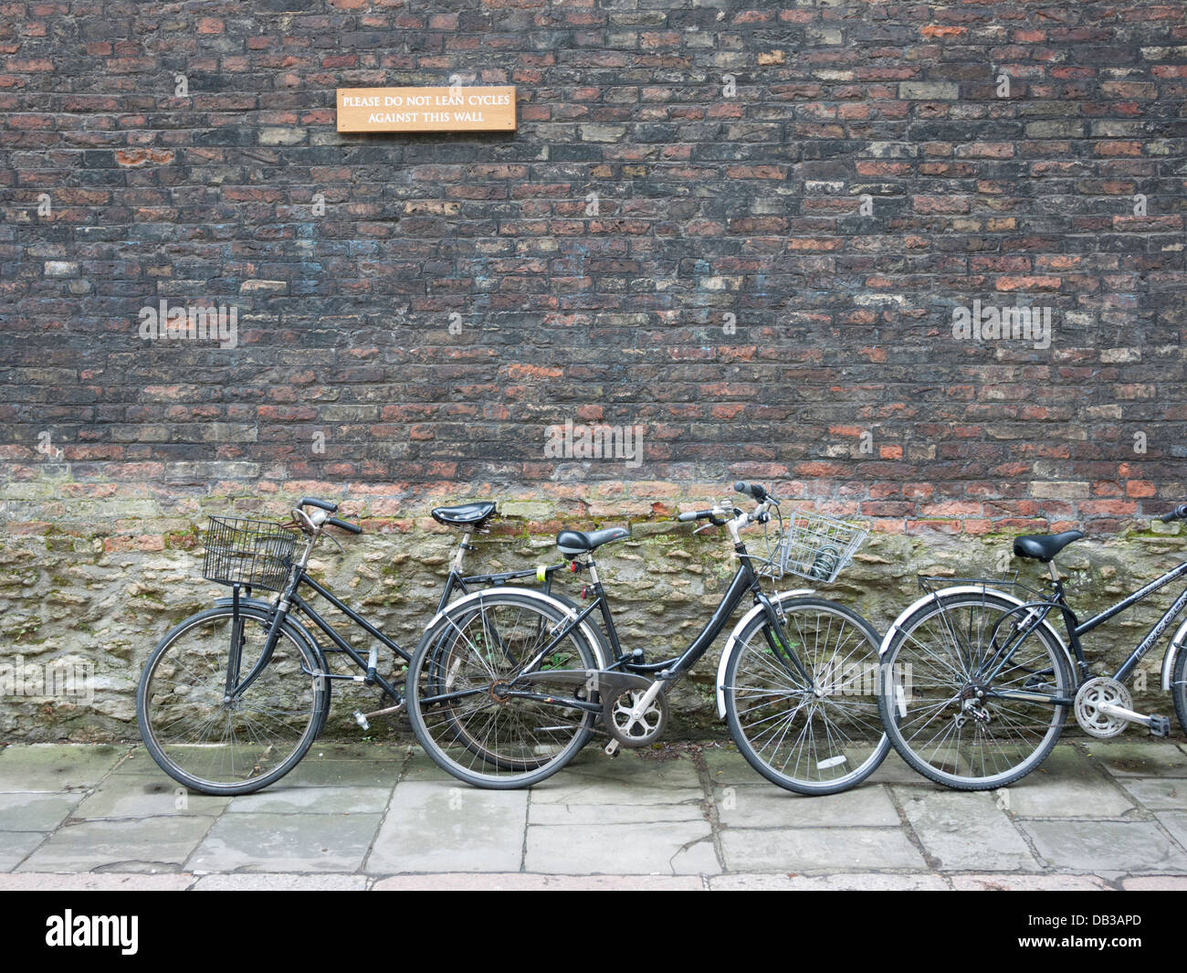 Fahrräder in Cambridge UK unter einem Schild mit der Aufschrift keine Zyklen eine Wand gelehnt Stockfoto