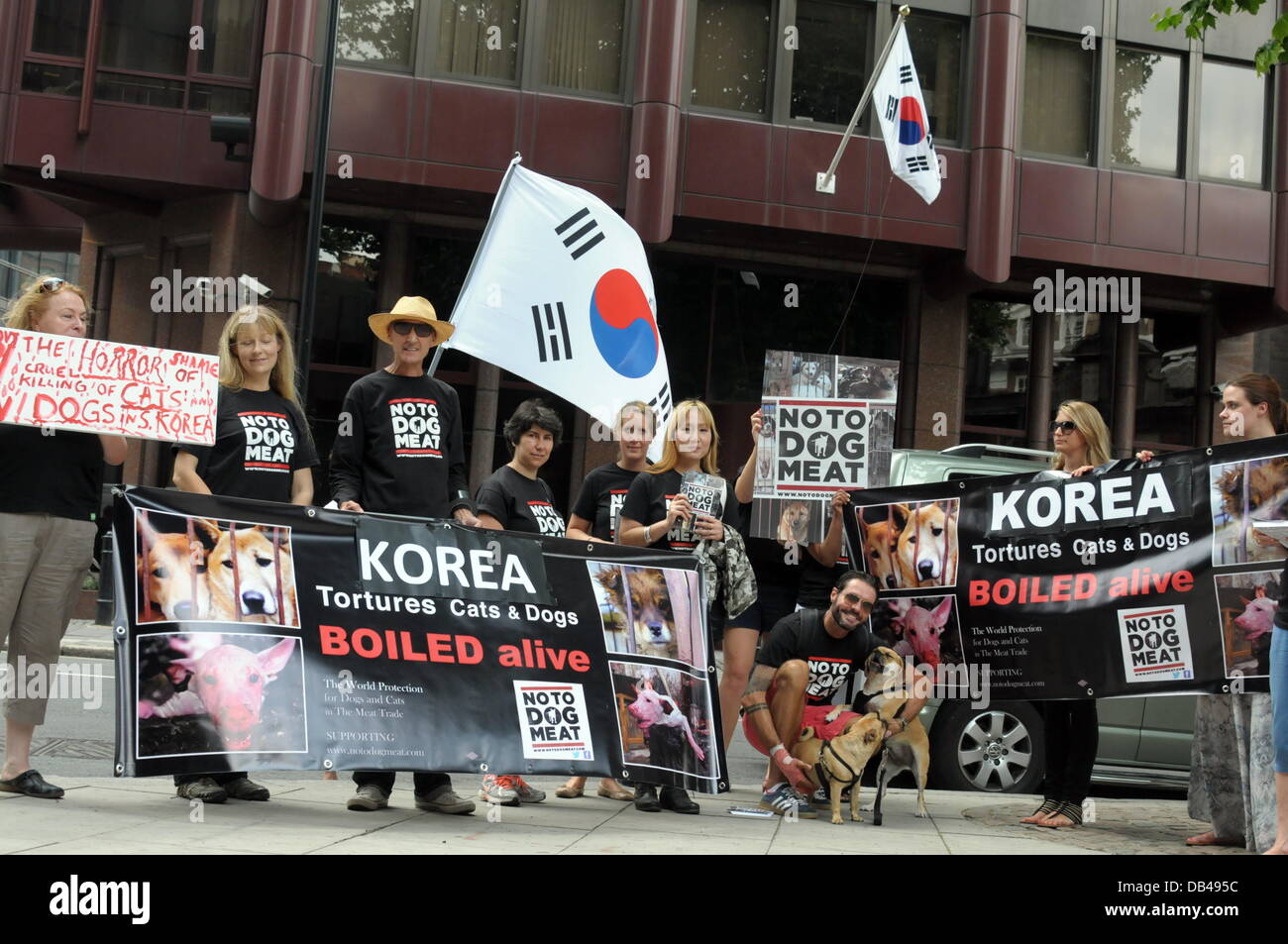 Wirkstoffe, die Abhaltung einer koreanischen Flagge und Plakate protestieren gegen die Republik Korea in den nächsten 60 Tagen für den Hund Essen Festival Bokdays außerhalb der koreanischen Botschaft in London. Stockfoto