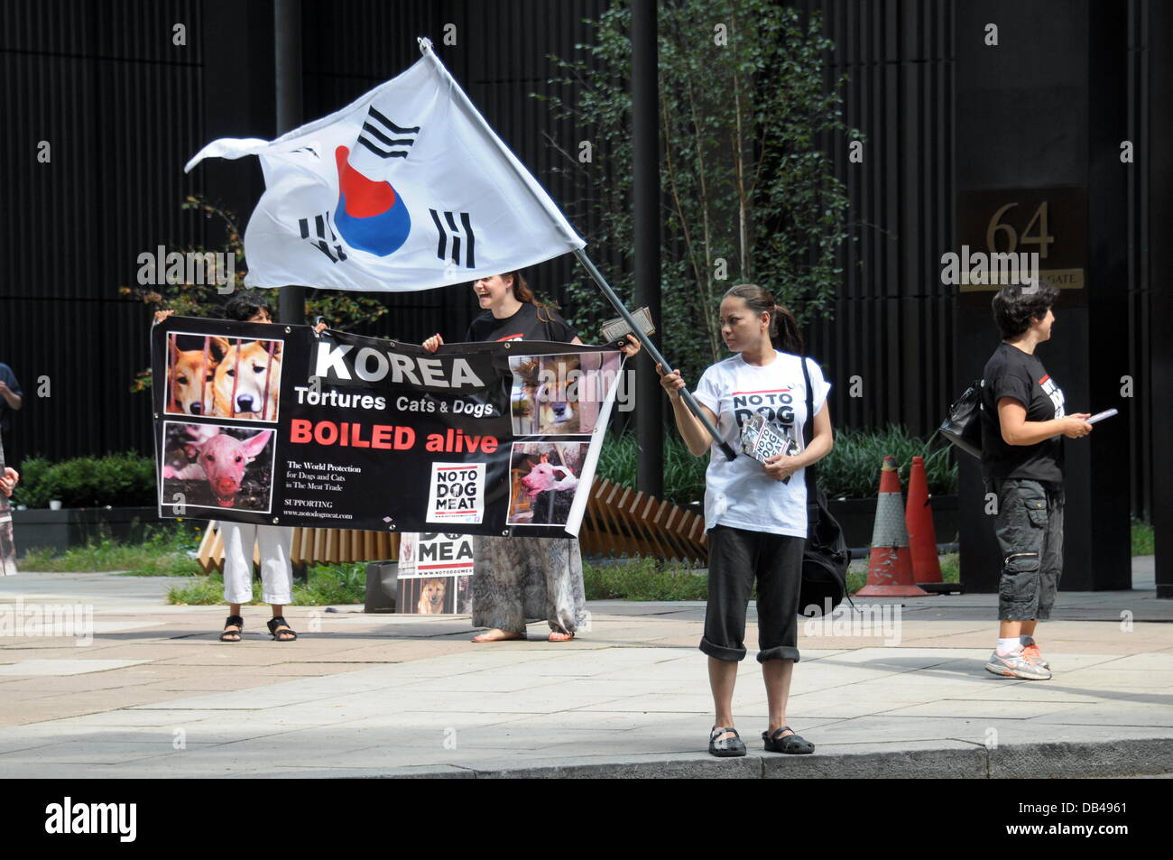Actives winken koreanische Flagge Protest gegen Südkorea der fünfzehn tausend Hunde werden brutal getötet täglich in Südkorea in den nächsten 60 Tagen für den Hund Essen Festival Bokdays außerhalb der koreanischen Botschaft in London. Stockfoto