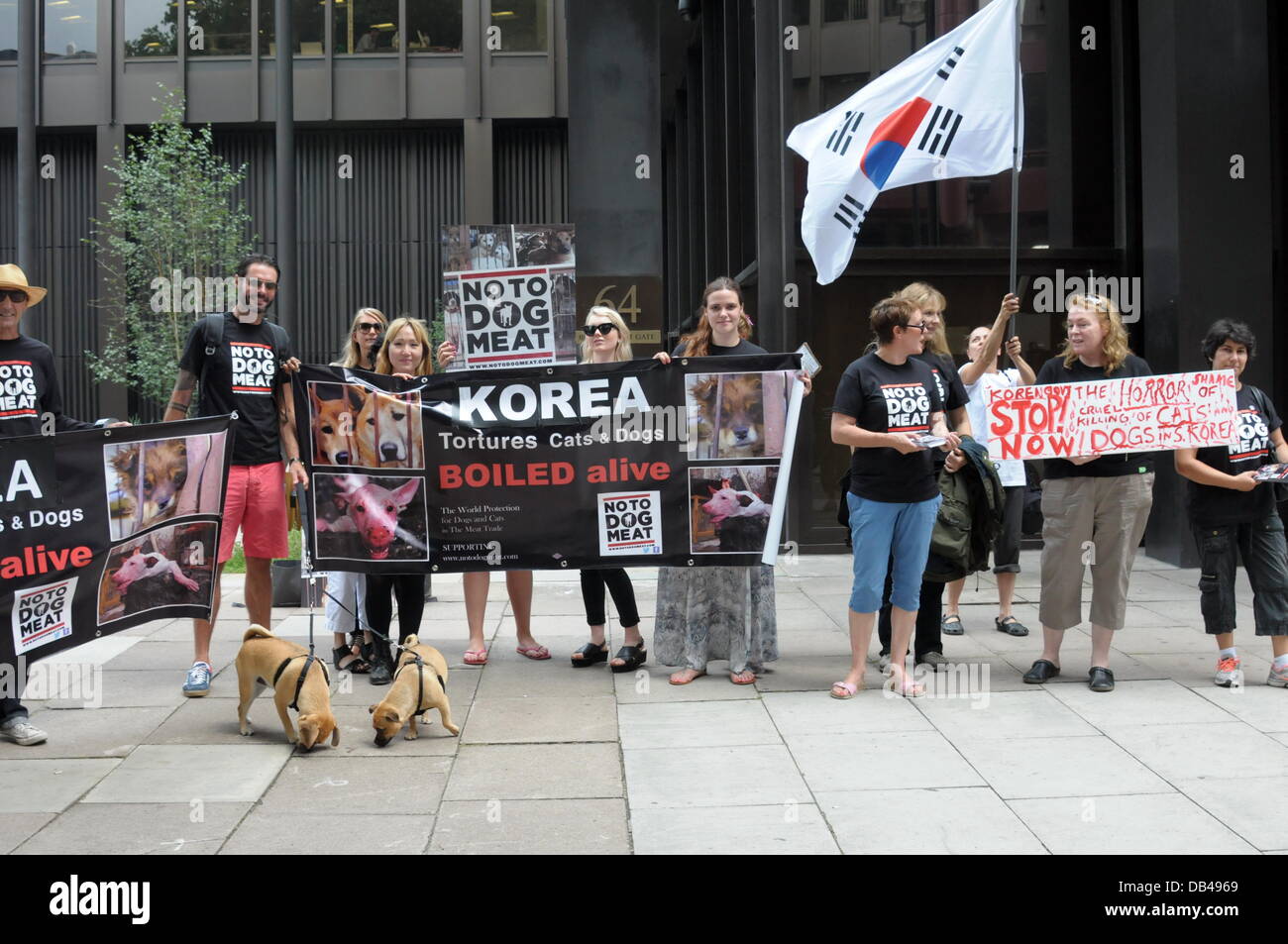 Wirkstoffen eine koreanische Flagge winken und halten Plakate Protest gegen Südkorea der fünfzehn tausend Hunde werden brutal getötet täglich in Südkorea in den nächsten 60 Tagen für den Hund Essen Festival Bokdays außerhalb der koreanischen Botschaft in London. Stockfoto