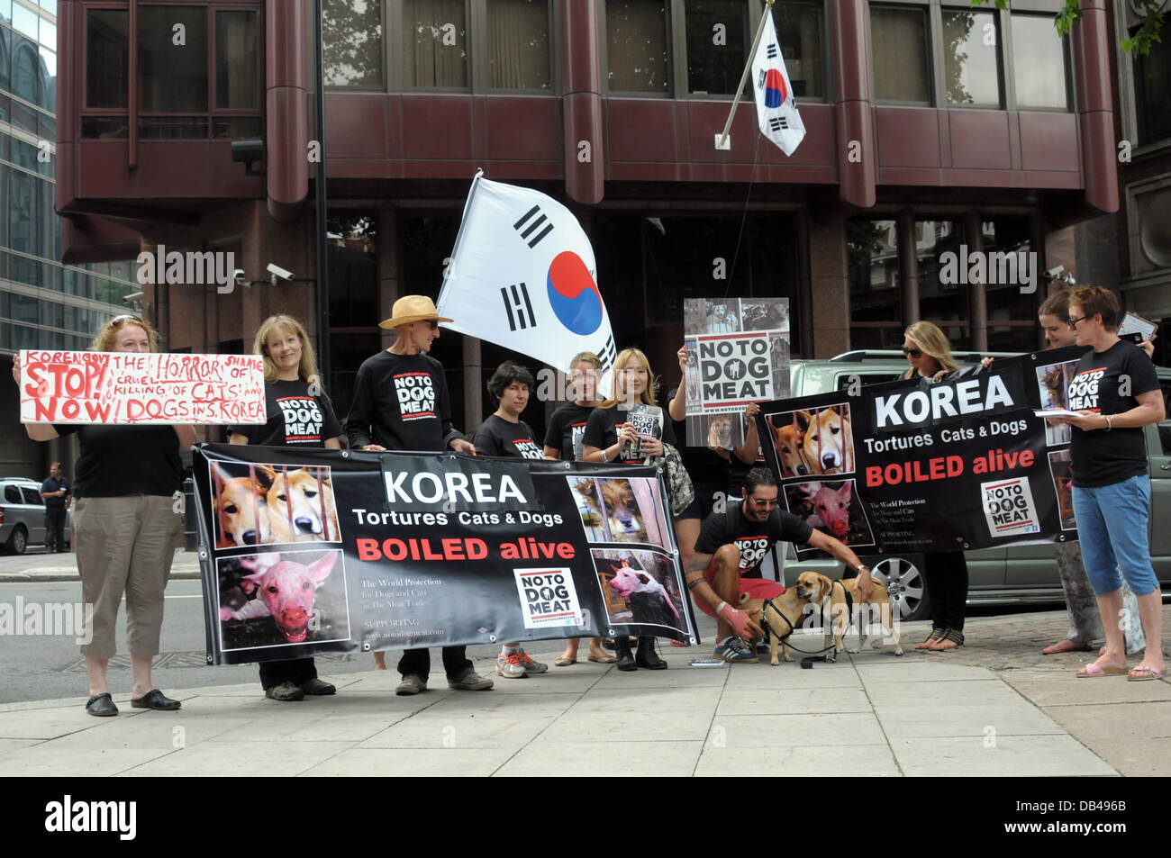 Wirkstoffe, die Abhaltung einer koreanischen Flagge und Plakate protestieren gegen die Republik Korea in den nächsten 60 Tagen für den Hund Essen Festival Bokdays außerhalb der koreanischen Botschaft in London. Stockfoto