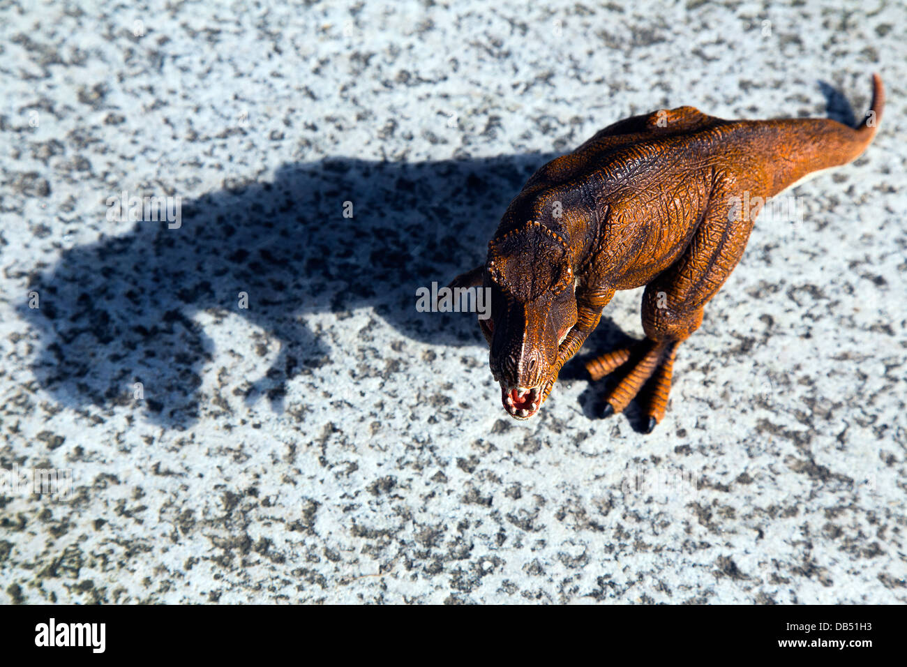 T-Rex Spielzeug auf einem Marmor Oberfläche mit einem definierten Schatten Stockfoto