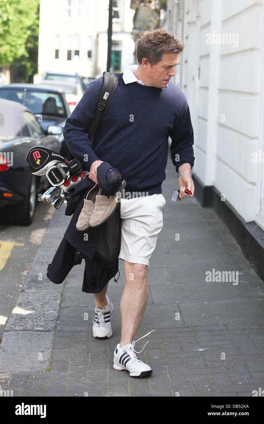 Hugh Grant trägt seine Golfschläger zurück zu seinem Haus London, England - 22.04.11 Stockfoto