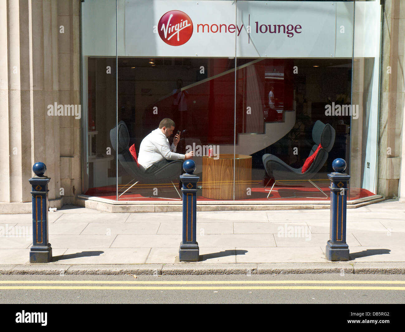 Mann auf dem Handy sitzen in Virgin Geld Lounge, Manchester UK Stockfoto