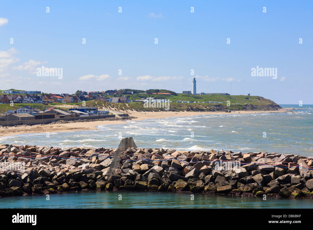 Zeigen Sie über die Hafenmauer Tornby Strand Strand und Leuchtturm an der dänischen Küste an. Hirtshals, Nordjütland, Dänemark Stockfoto