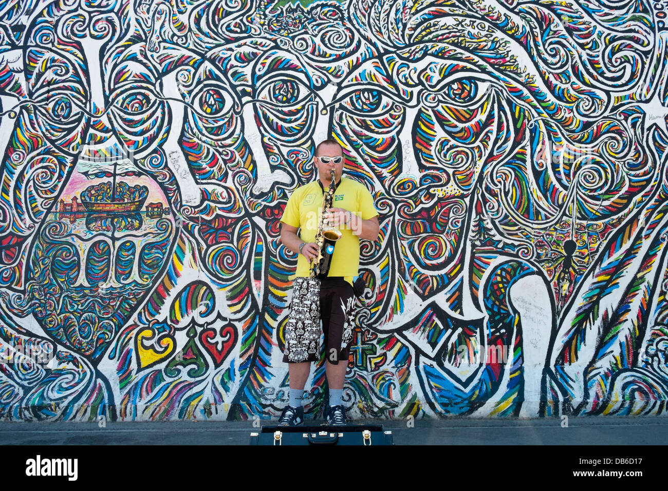 Musiker als Straßenmusikant auf Straße neben der Berliner Mauer an der East Side Gallery in Berlin Deutschland Stockfoto