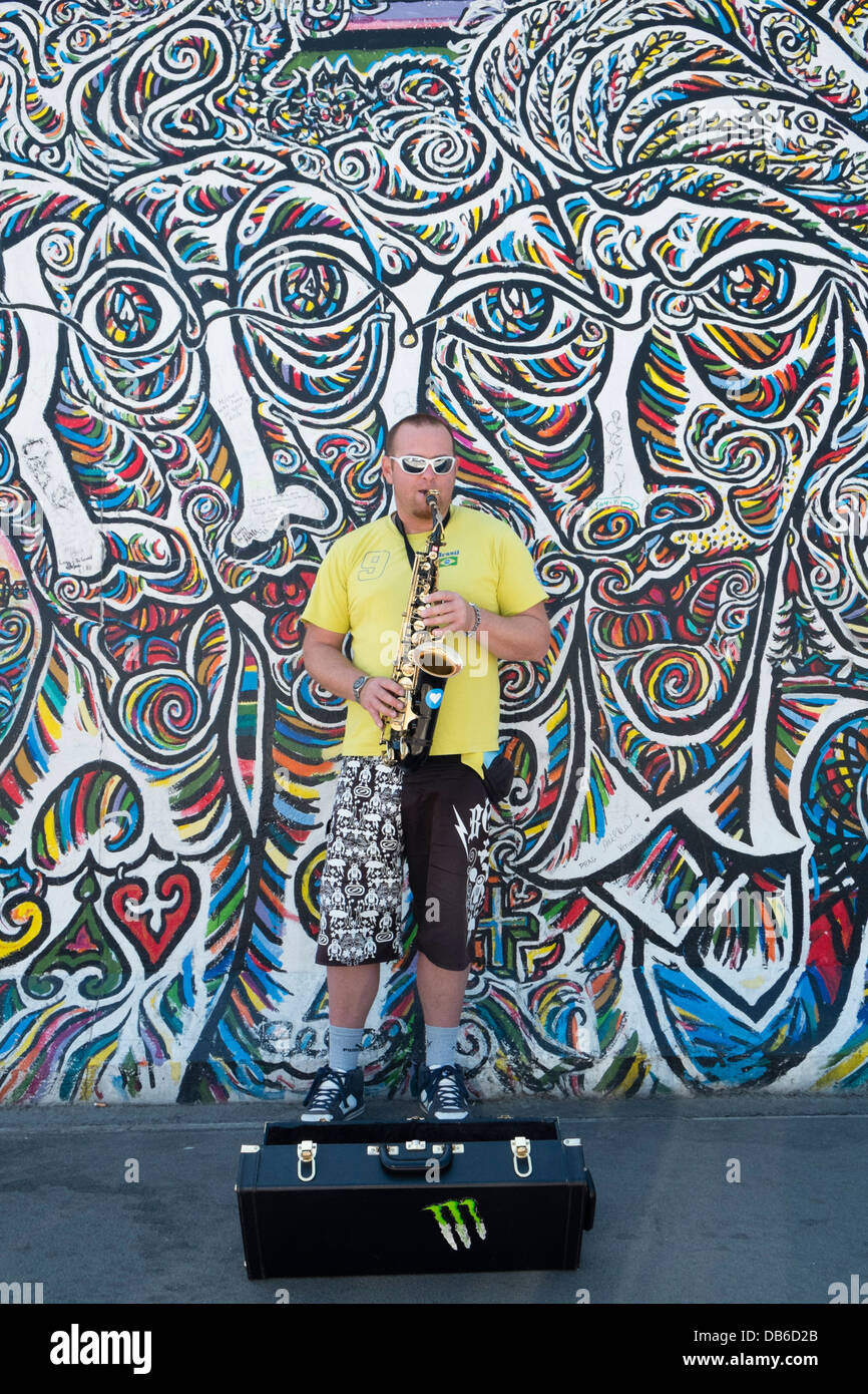 Musiker als Straßenmusikant auf Straße neben der Berliner Mauer an der East Side Gallery in Berlin Deutschland Stockfoto