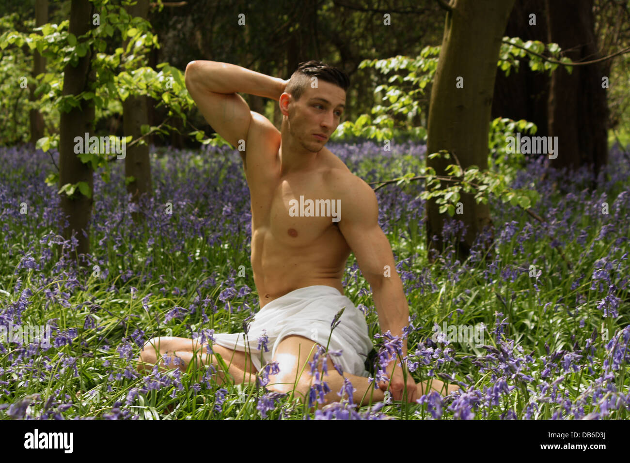 Ein männliches Modell sitzen in einem Lavendelfeld. Stockfoto