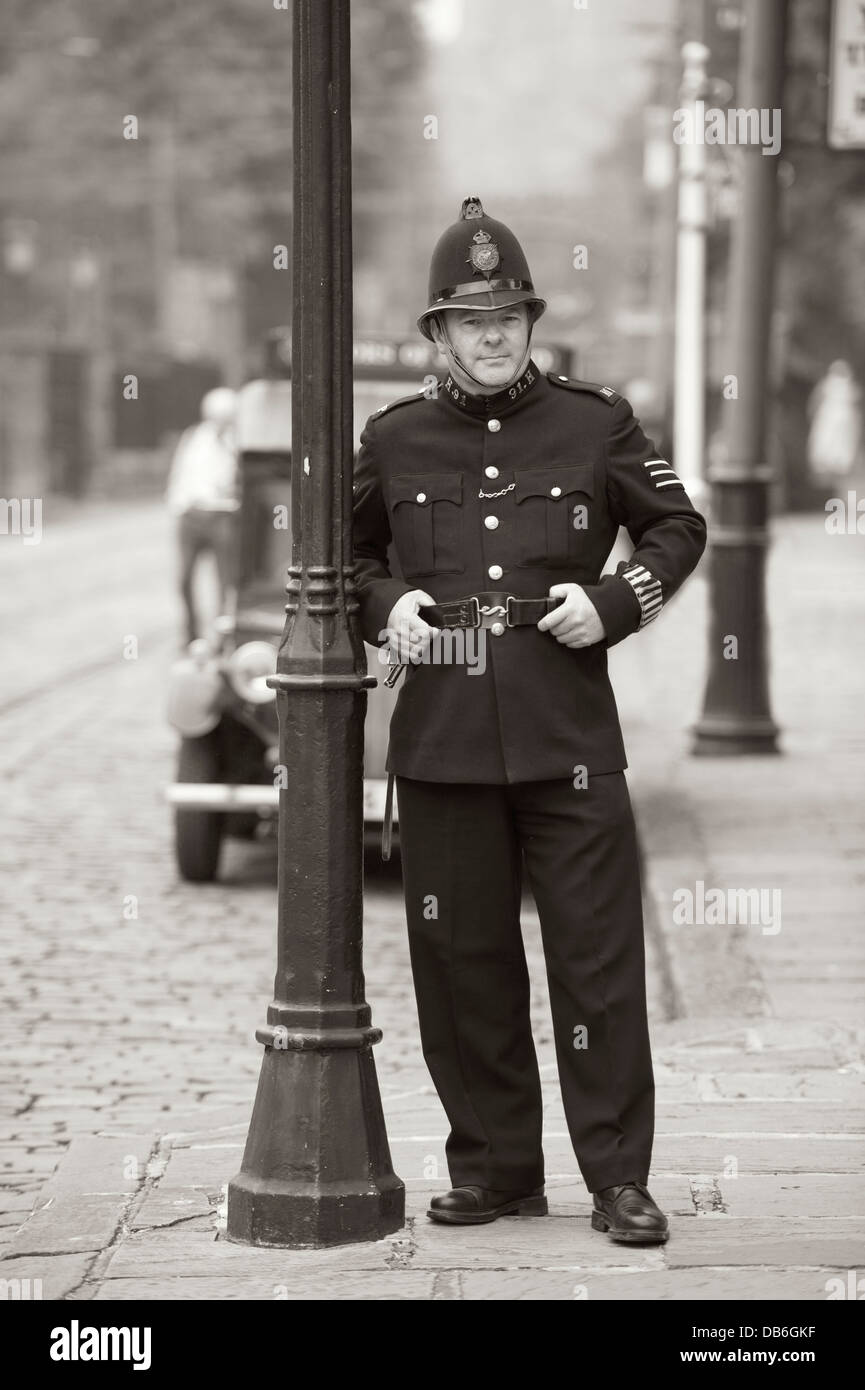 ein Polizist aus der edwardian Ära oder 1910 Periode stützte sich auf einen Laternenpfahl Stockfoto