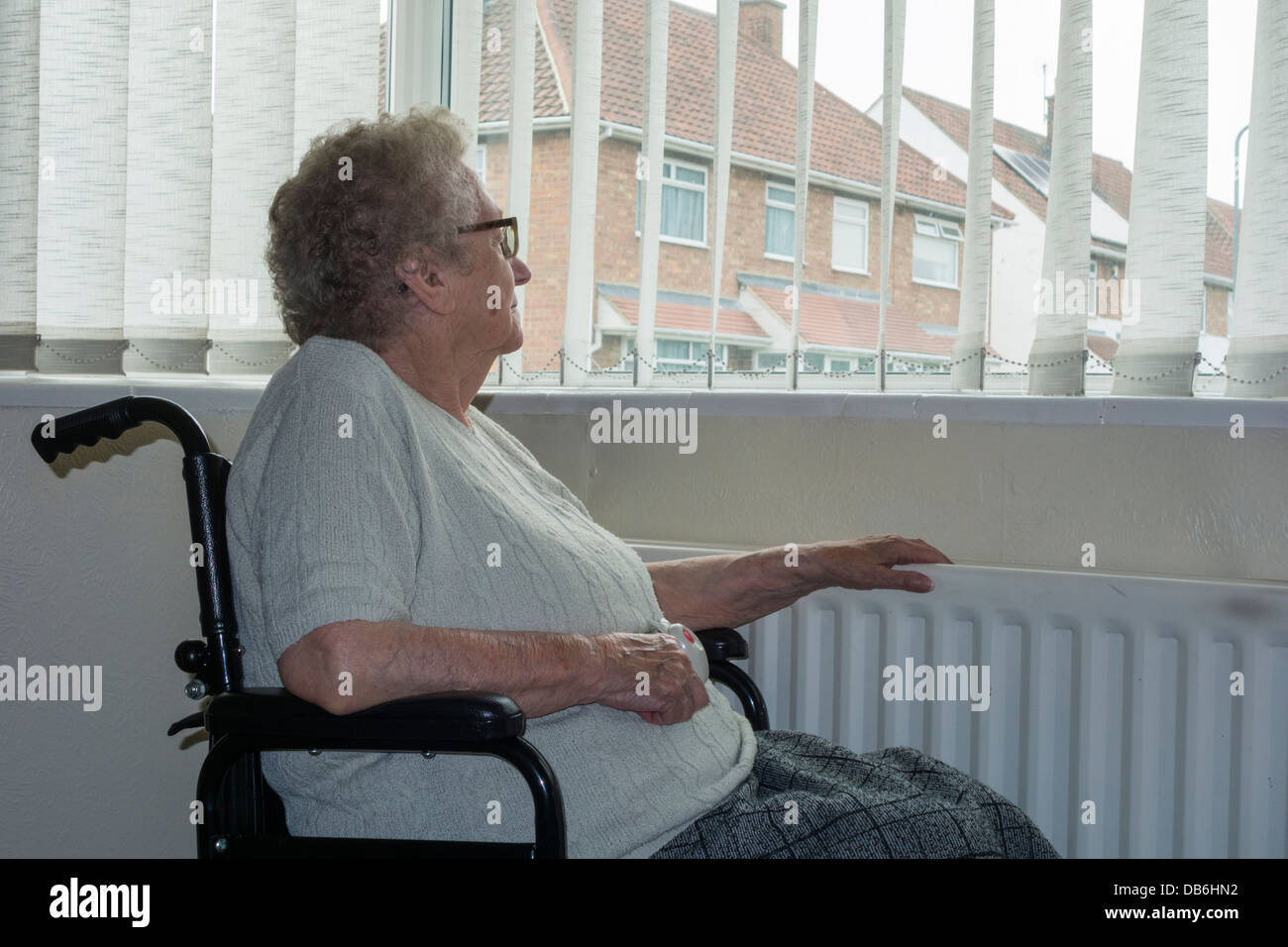 Neunzigjährige Frau mit Hand am Kühler aus dem Fenster. GROSSBRITANNIEN. Coronavirus, Selbstisolation, soziale Distanzierung, Quarantäne... Konzept Stockfoto