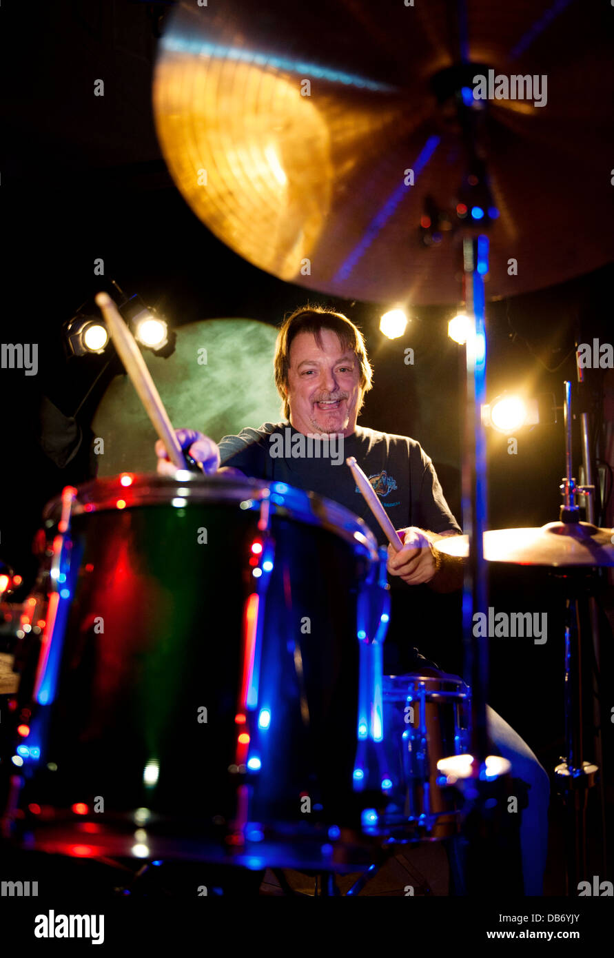 Mann, spielt Schlagzeug auf der Bühne. Des Logos wurden in Photoshop aus Trommeln und Becken entfernt. Stockfoto