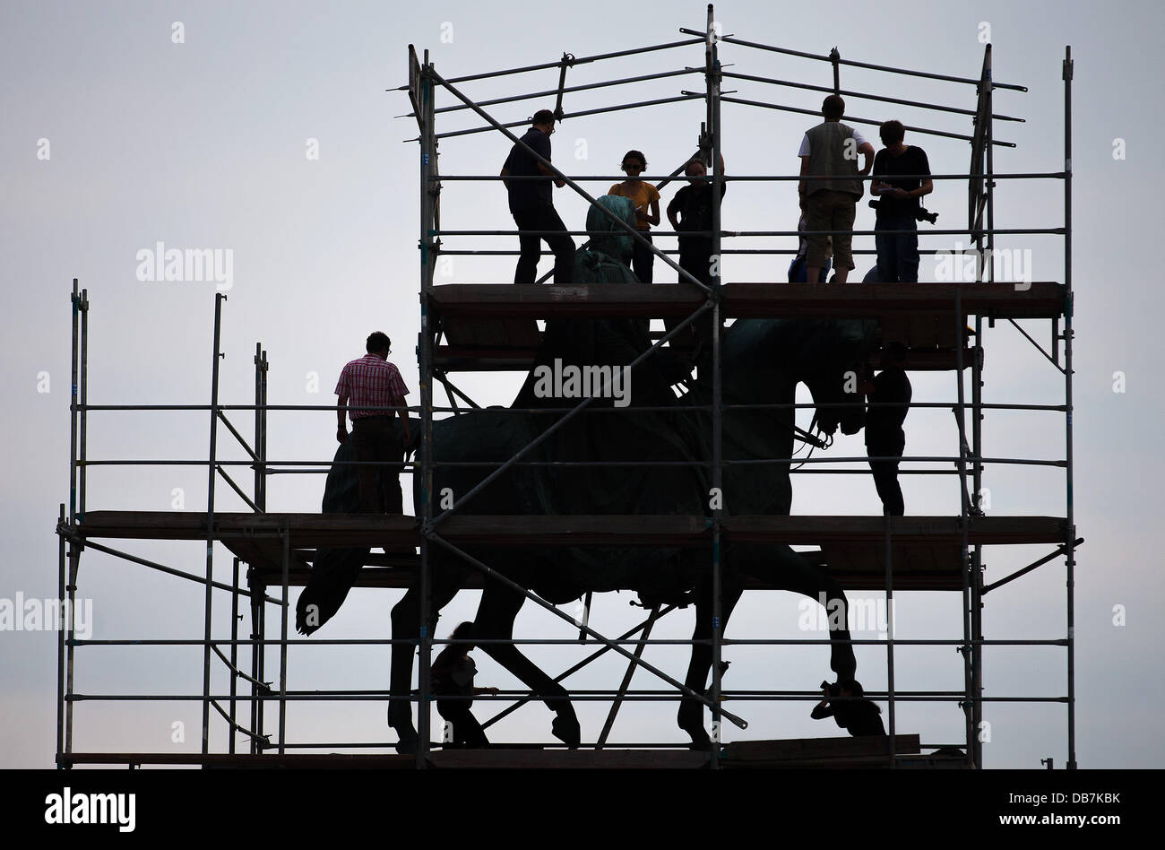 Restauratoren und Journalisten stehen auf dem Schafott vor das bronzene Reiterstandbild des Königs Johann von Sachsen an der Semperoper in Dresden, Deutschland, 25. Juli 2013. Für rund 75 000 Euro werden die Oberflächen der Statue vor Schmutz, Staub und Rost Ablagerungen gereinigt. Im Jahre 1889 vom Bildhauer Johannes Schilling geschaffen erinnert das Denkmal König Johann von Sachsen (1801-1873), die den Bau der Semperoper in Auftrag gegeben. Foto: Hannibal Stockfoto