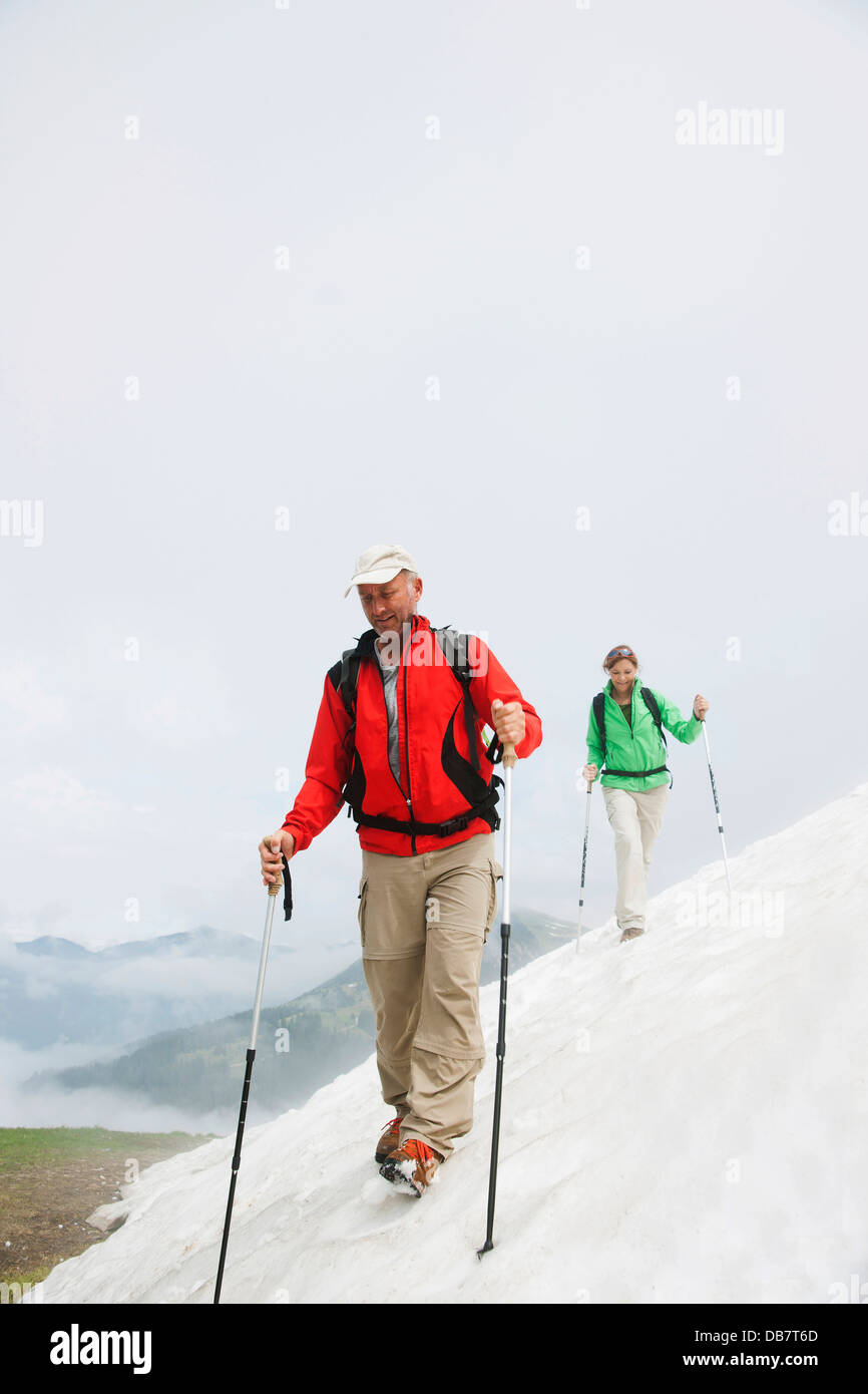 Paar bewegen über ein Schneefeld während ihrer Wanderung zum Mt. Neunerkoepfle Stockfoto