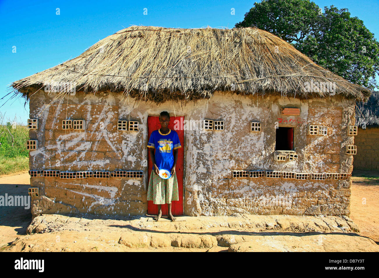 Afrikanische Länder - Angola-Frau steht vor Tür kleine Ton Lehmhütte in Angila Stroh Dach Landleben Armut schwer Stockfoto