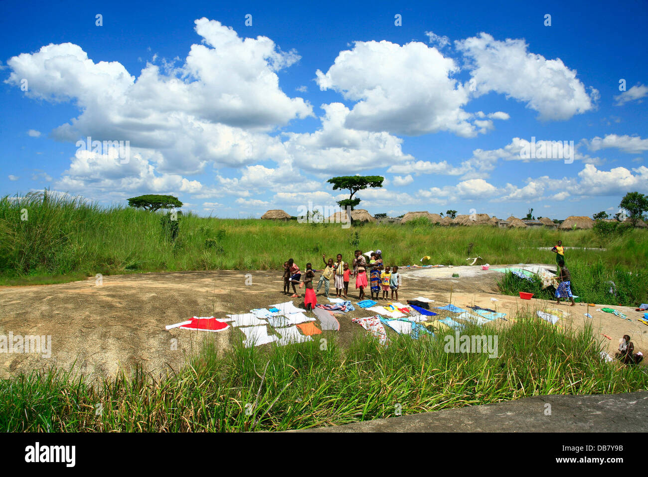 Afrikanische Länder - Angola Kinder afrikanischen Dorf stehen in der Nähe von waschen, trocknen in der Sonne Waschtag in Afrika, die gewaschene Wäsche Stockfoto