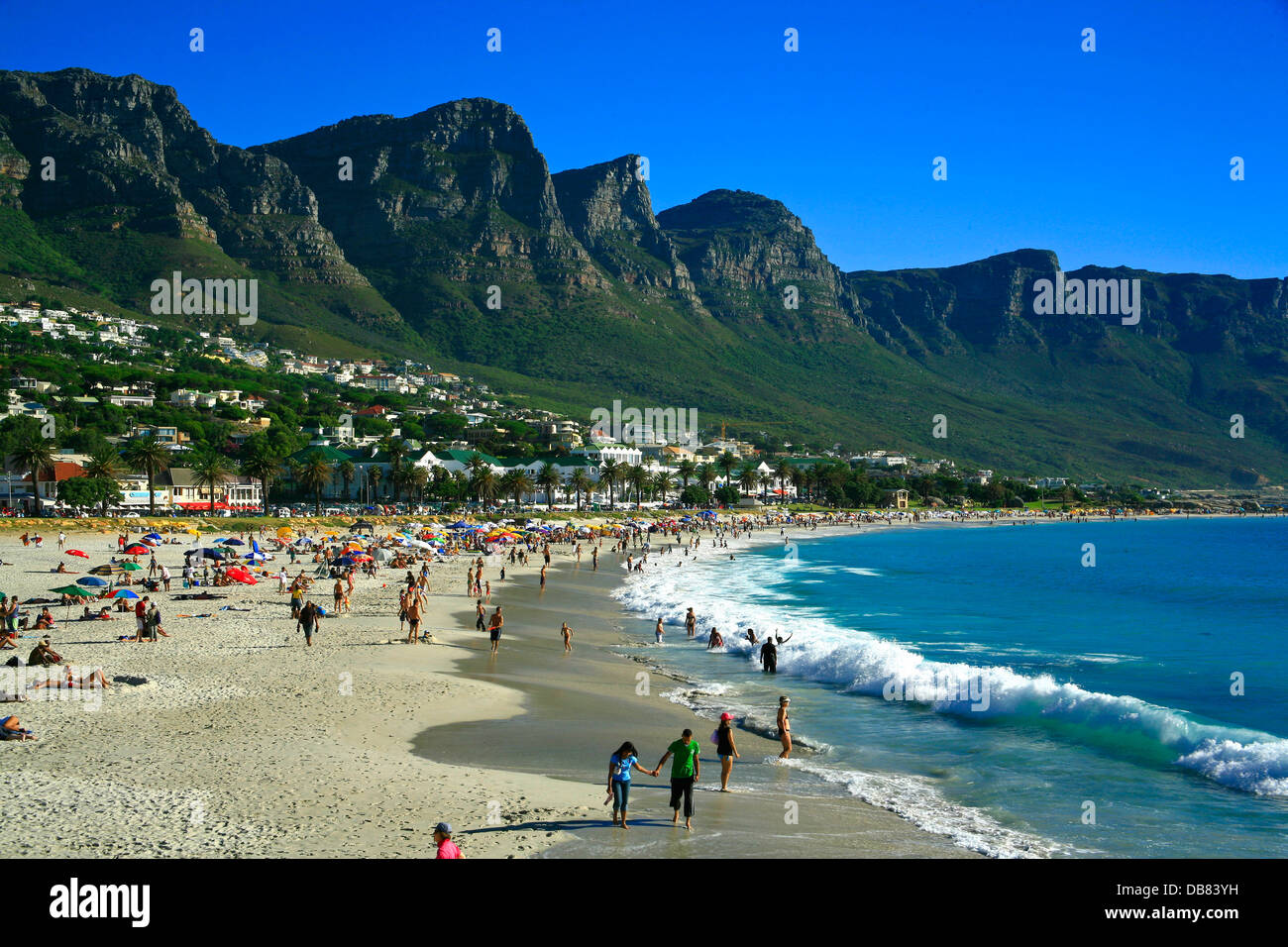 Südafrika - Kapstadt - Camps Bay Strand Atlantik Berge 12 Apostel Vorstadt Sand Leute sitzen am Strand Küste Stockfoto