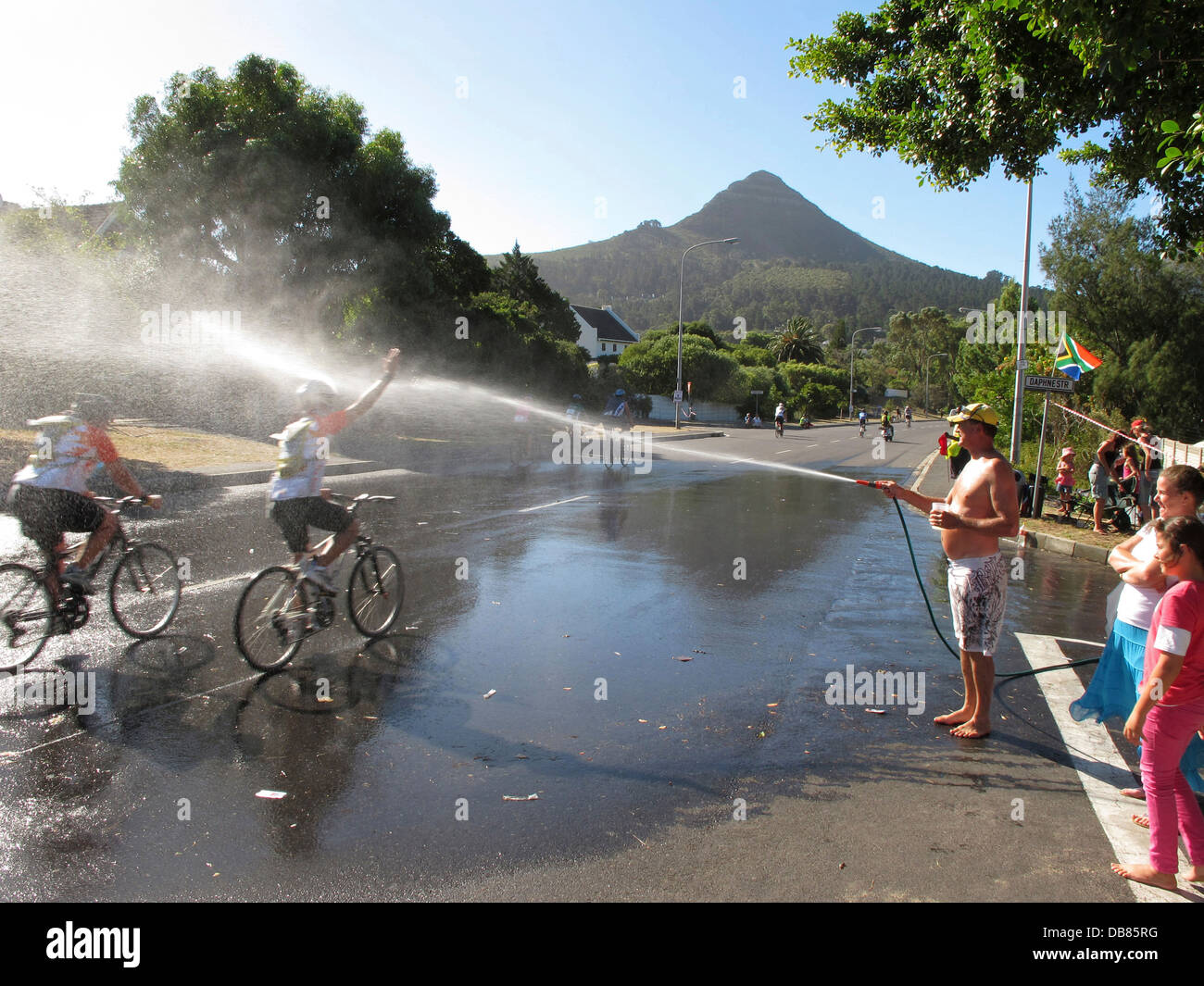 Radfahrer bekommen Spritzwasser in Hout Bay Argus Cycle Tour über 110km über Kap-Halbinsel größte zeitgesteuerte Radrennen Welt Stockfoto