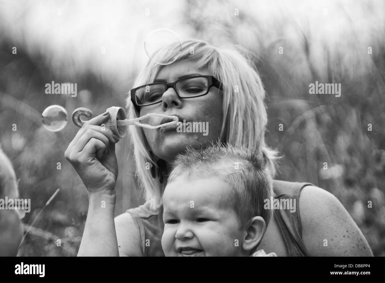 Mutter mit Kind spielen mit Blase Gebläse Stockfoto