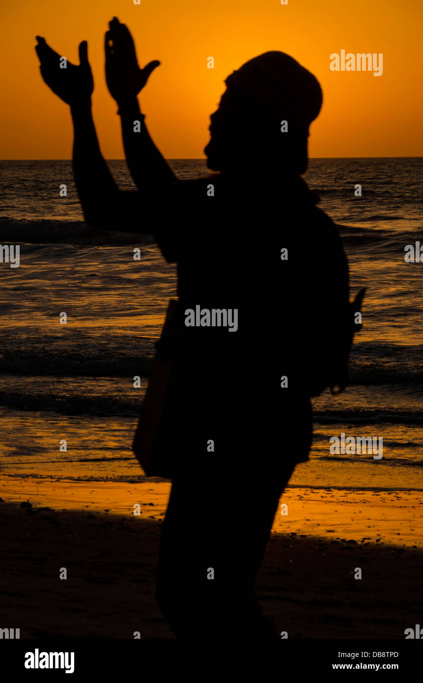 Den Sonnenuntergang genießen, einen Musik-Mann am Strand von Kololi Gambia Westafrika Stockfoto