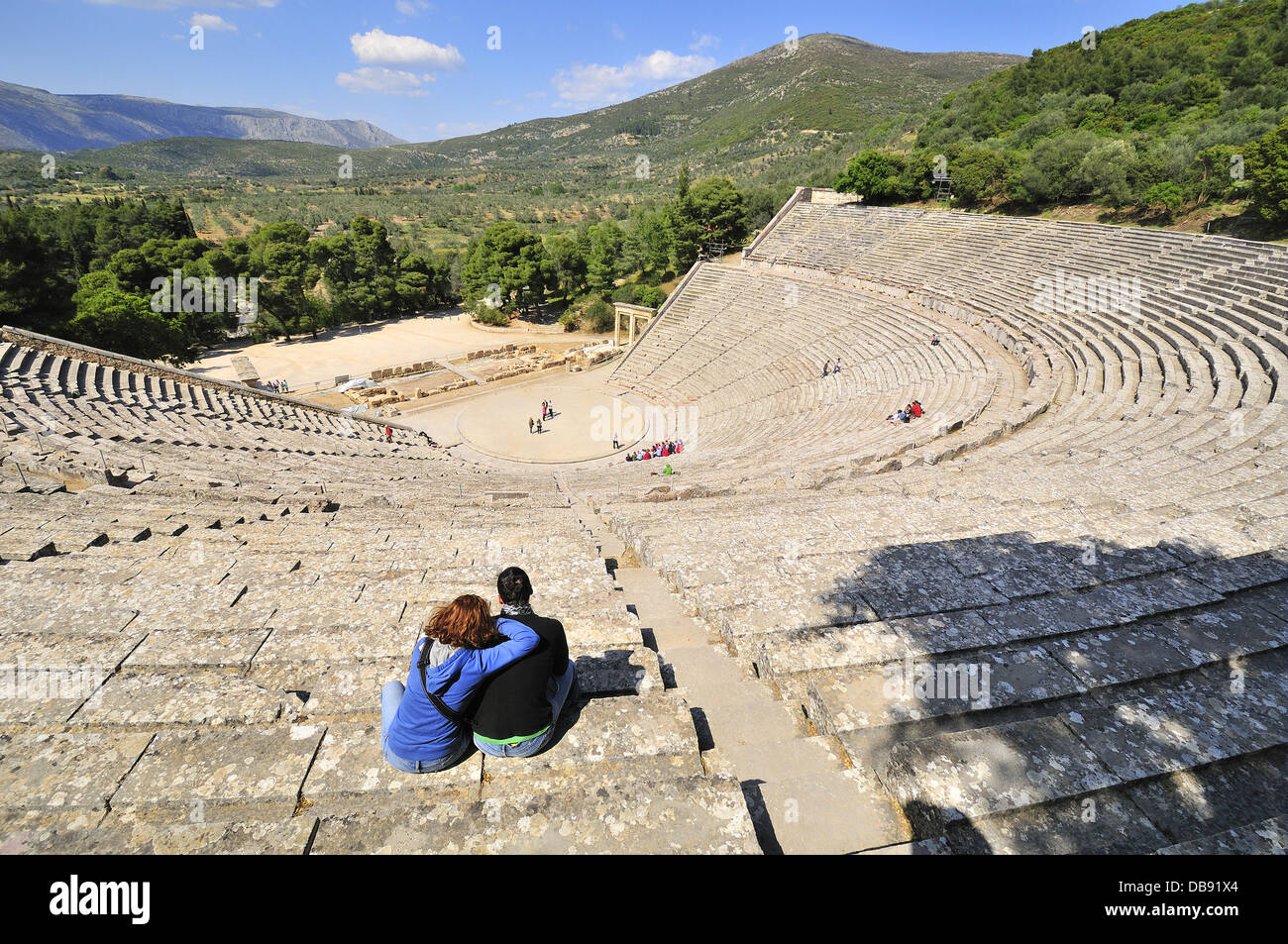 Altes Theater von Epidavros mit einem Paar auf den Terrassen, die Platz für bis zu 15.000 Personen bieten, Peloponnes, Griechenland Stockfoto