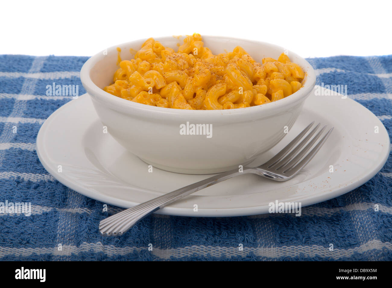 Makkaroni und Käse aus verpackten Mischung in Schüssel auf einen blauen Tischset weiß Stockfoto