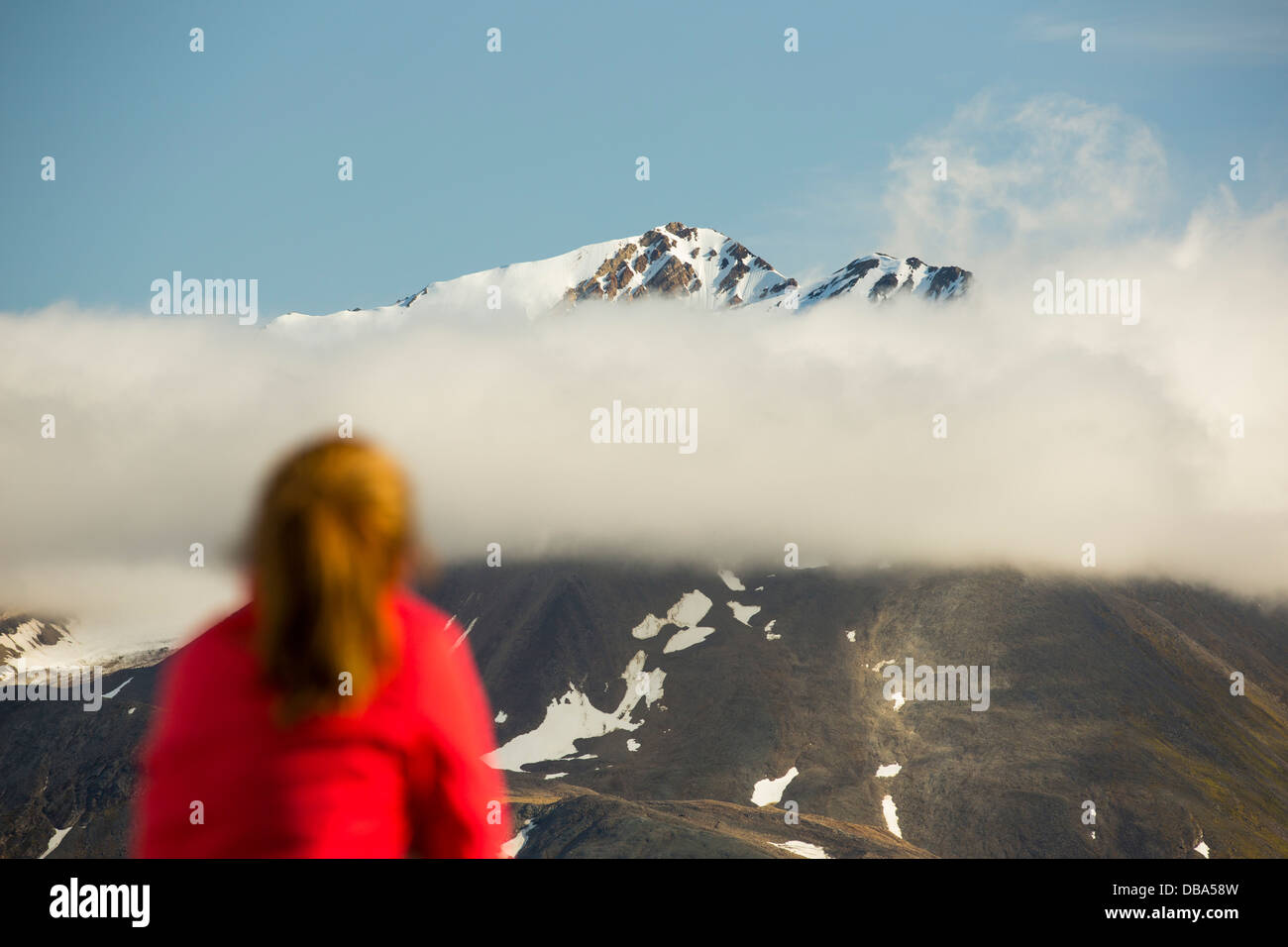 Eine Frau, die Berggipfel im nördlichen Svalbard von einer Expedition Kreuzfahrtschiff anzeigen. Stockfoto