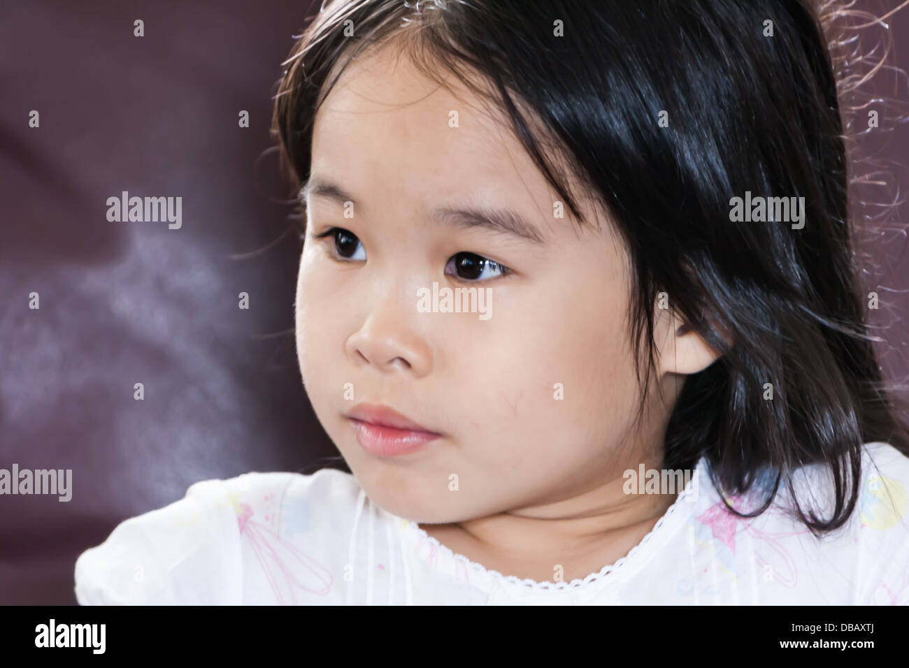 Kleine süße asiatische Mädchen auf der Suche nach etwas und denken aussehen zerstreut Stockfoto
