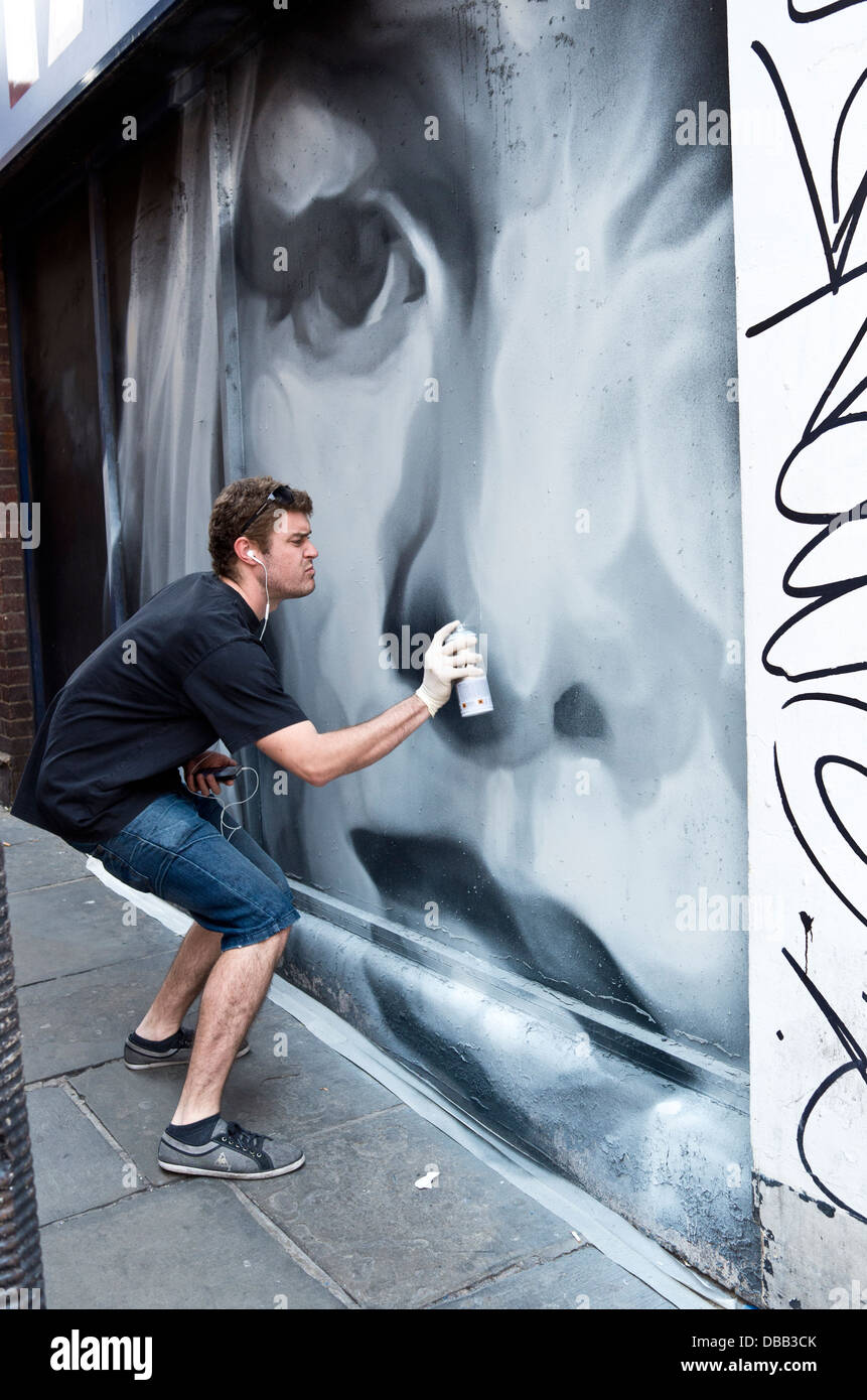 Graffiti-Künstler bei der Arbeit am Wandbild. Stockfoto