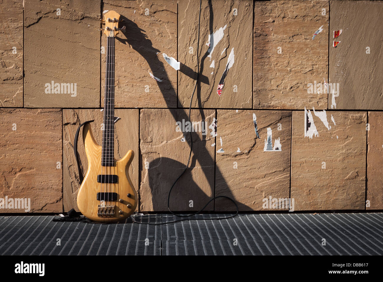 Bass-Gitarre und Verstärker gegen eine Steinmauer Stockfoto