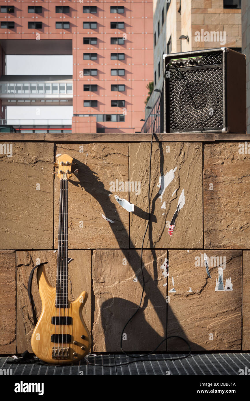 Bass-Gitarre und Verstärker gegen eine Steinmauer Stockfoto