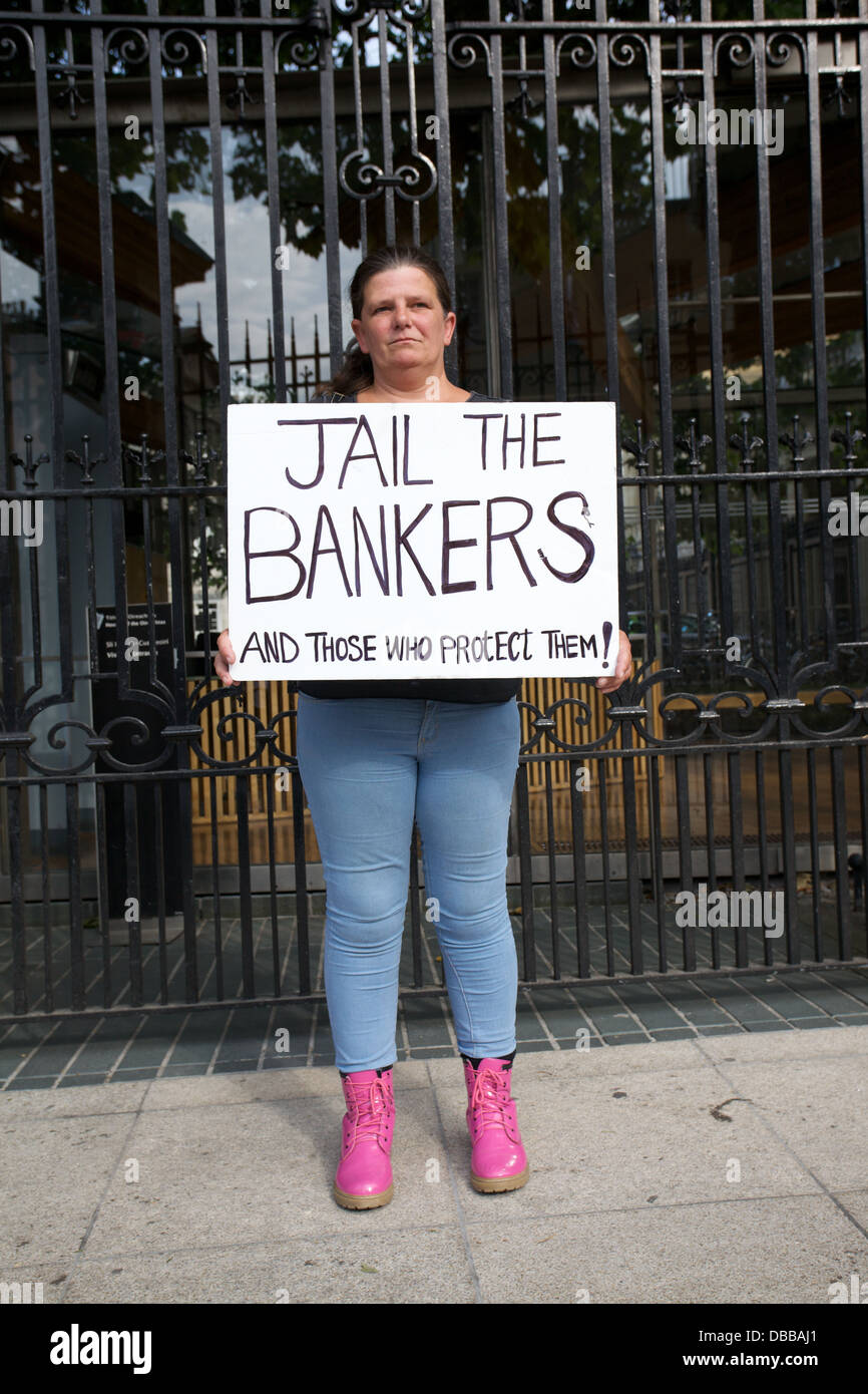 Porträt der Frau auf der Straße in Dublin, Irland, mit einem Protest-Plakat lesen Gefängnis die Banker Stockfoto