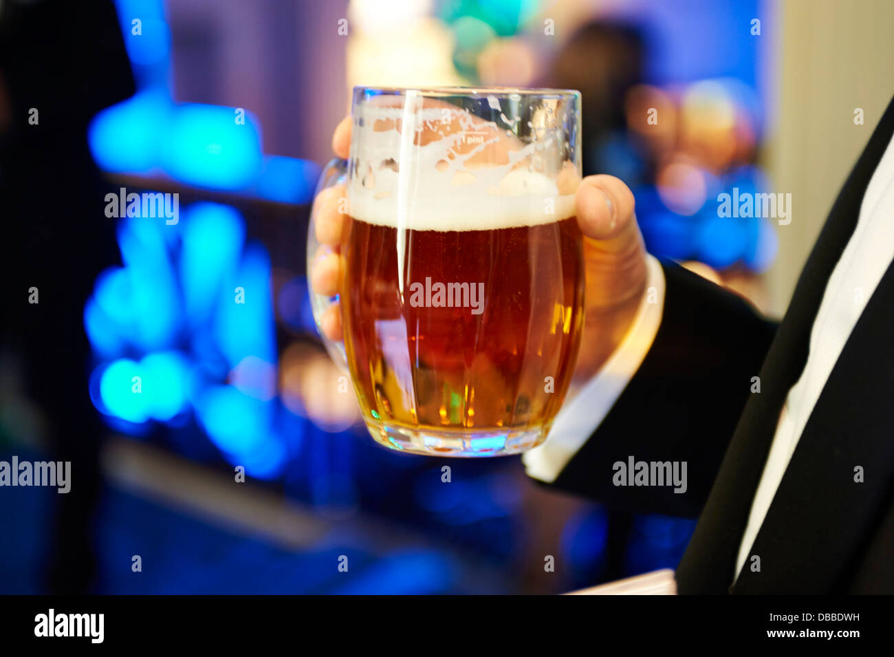 Mann hält ein Bier Stockfoto