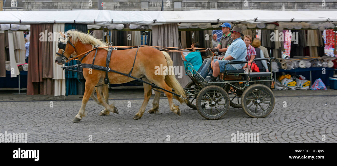 Maastricht City Menschen, die mit Pferdekutschen an Bekleidungsständen auf dem Marktplatz vorbeifahren warmer Sommer in Limburg Niederlande Europa Stockfoto