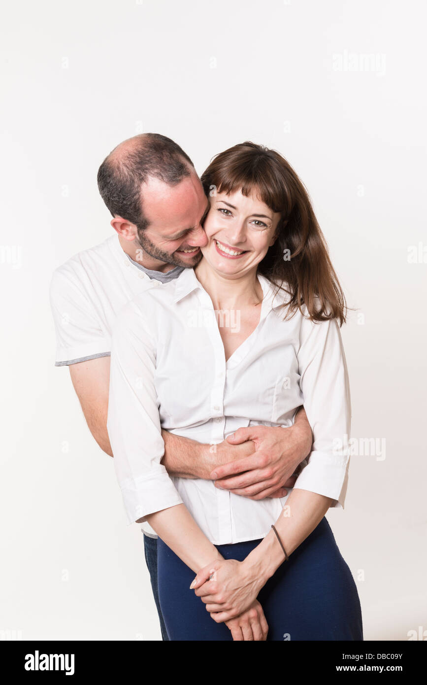 Junge Erwachsene kaukasischen Paar glücklich zusammen, Mann umarmt Frau von hinten Stockfoto