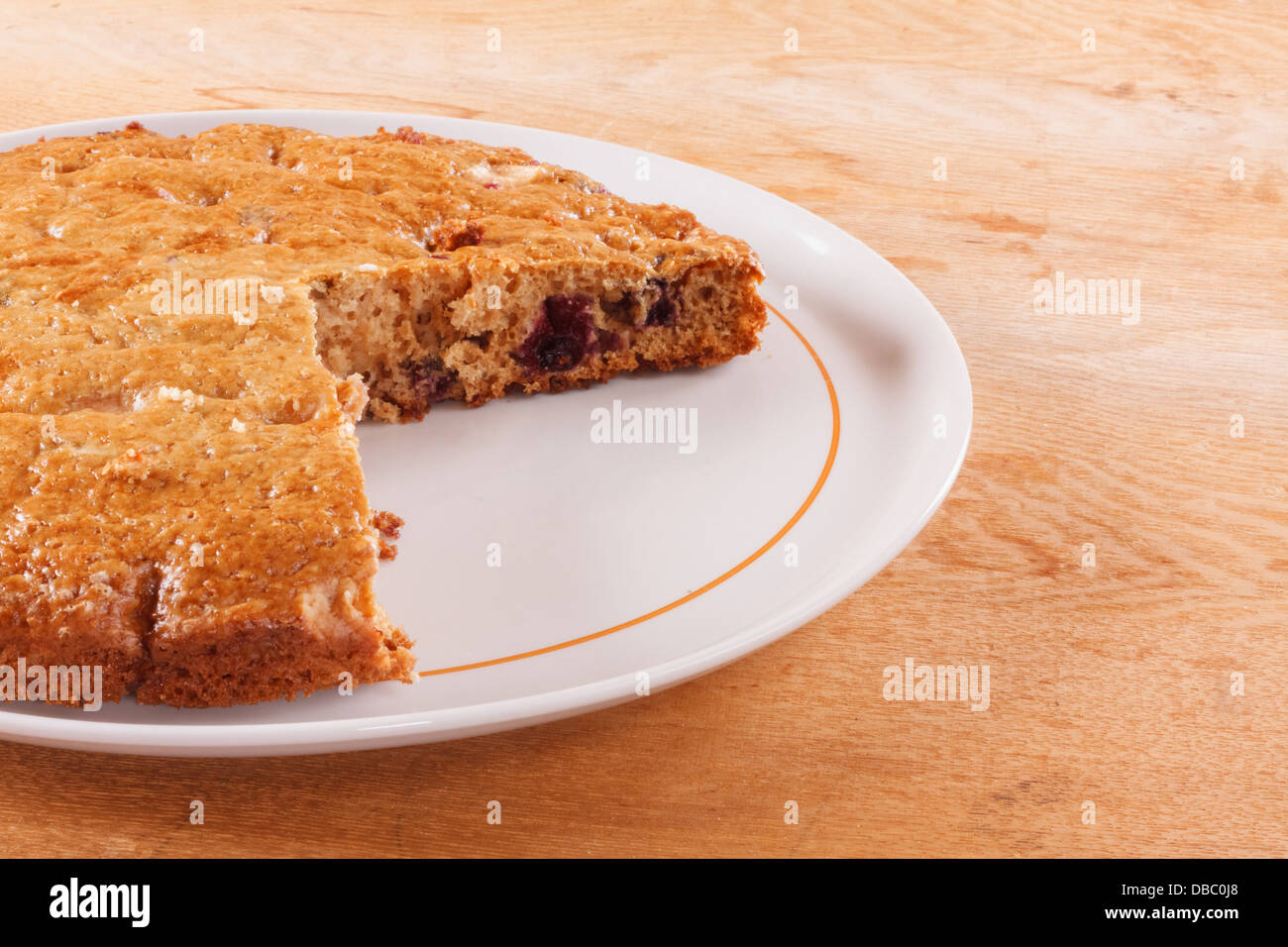 Hausgemachte Kuchen mit geschnittenen Stück auf einem Holztisch Stockfoto