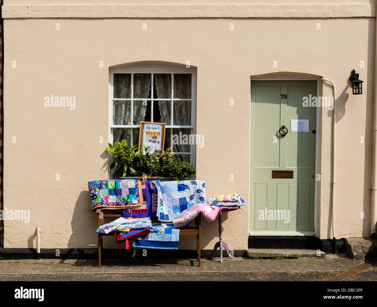Textilien für Verkauf zugunsten der Nächstenliebe auf dem Display vor einem Haus in Lavenham Stockfoto
