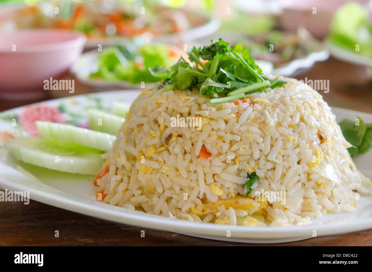 Gebratener Reis mit Gurkenscheiben auf weiße Schale serviert Stockfoto