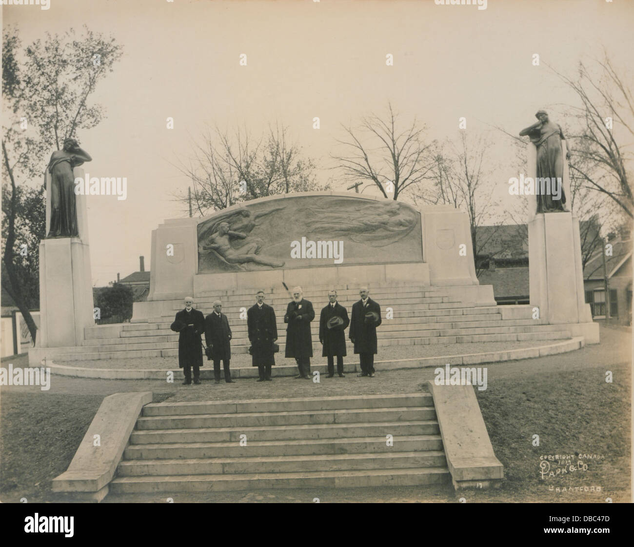 Ein Foto von Dr. Bell und einem Komitee, der vor dem Bell Memorial steht. Das Foto zeigt ein Ereignis im Zusammenhang mit der Gedenkstätte für Alexander Graham Bell, den Erfinder des Telefons. Stockfoto
