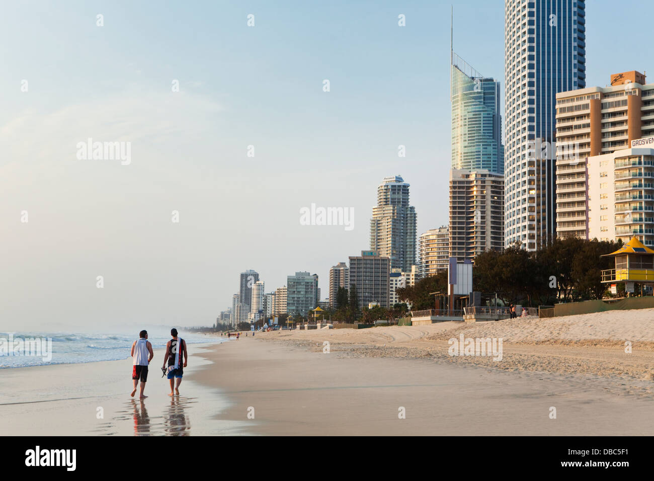 Touristen am Strand mit Skyline bei Surfers Paradise in der Morgendämmerung. Gold Coast, Queensland, Australien Stockfoto
