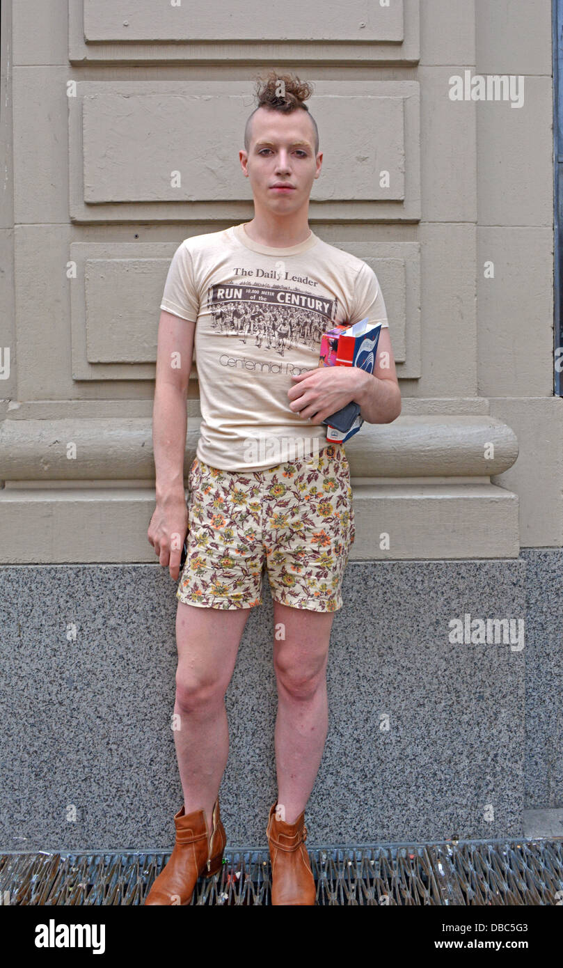 Junger Mann mit einem Mohawk-Frisur und ungerade Shorts mit Büchern in Greenwich Village New York City Stockfoto