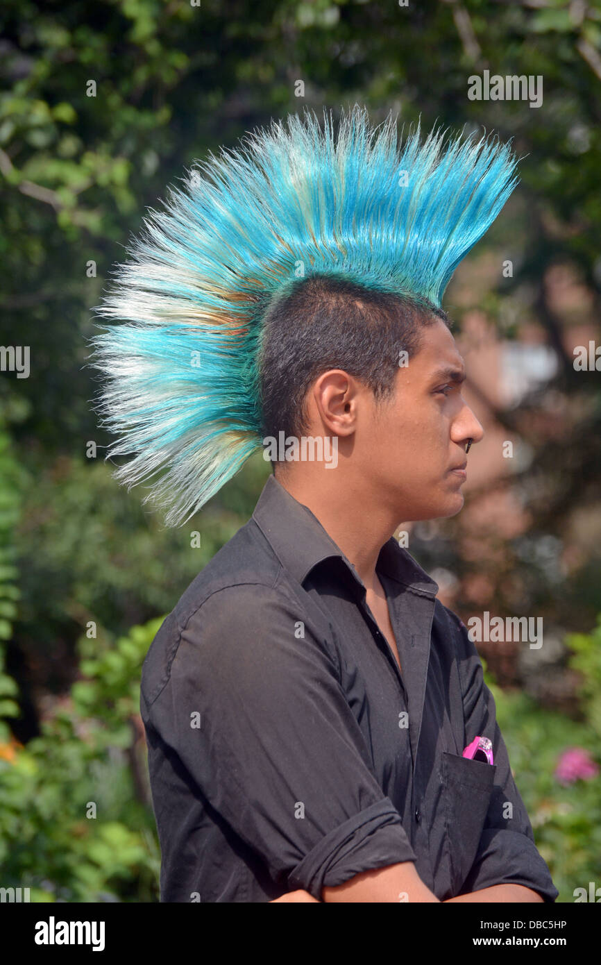 Profil-Porträt eines jungen Mannes mit einem bunten blauen Mohawk Haarschnitt am Union Square Park in New York City Stockfoto