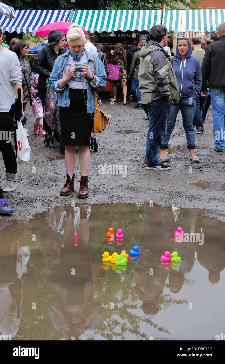 Nach sintflutartigen Regenfällen schweben Plastikenten auf einer großen Pfütze auf dem Merchant City Festival Market Place in Glasgow. Stockfoto