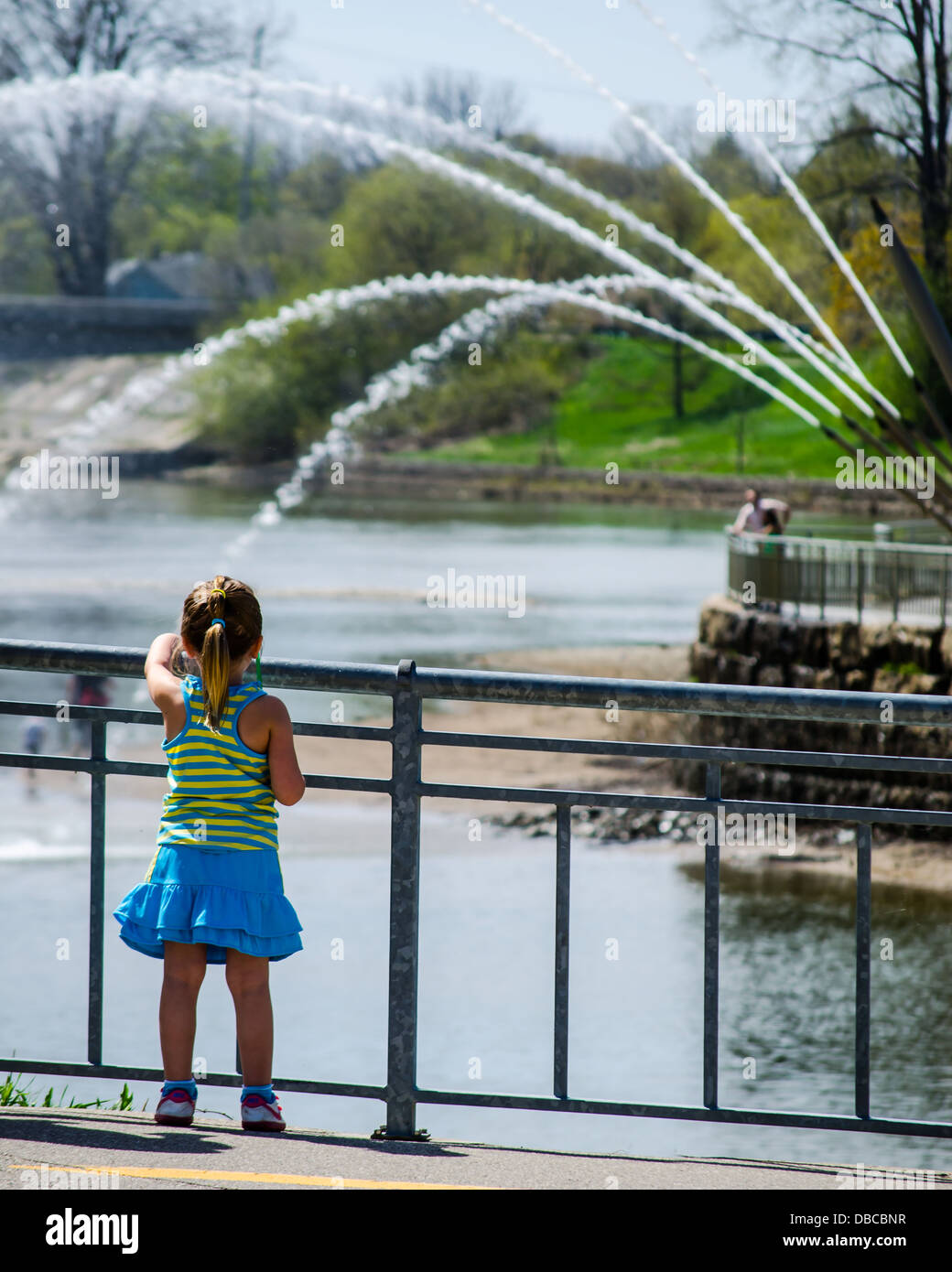 Ein kleines Mädchen am Fluss Wasser Brunnen erstaunt. Stockfoto