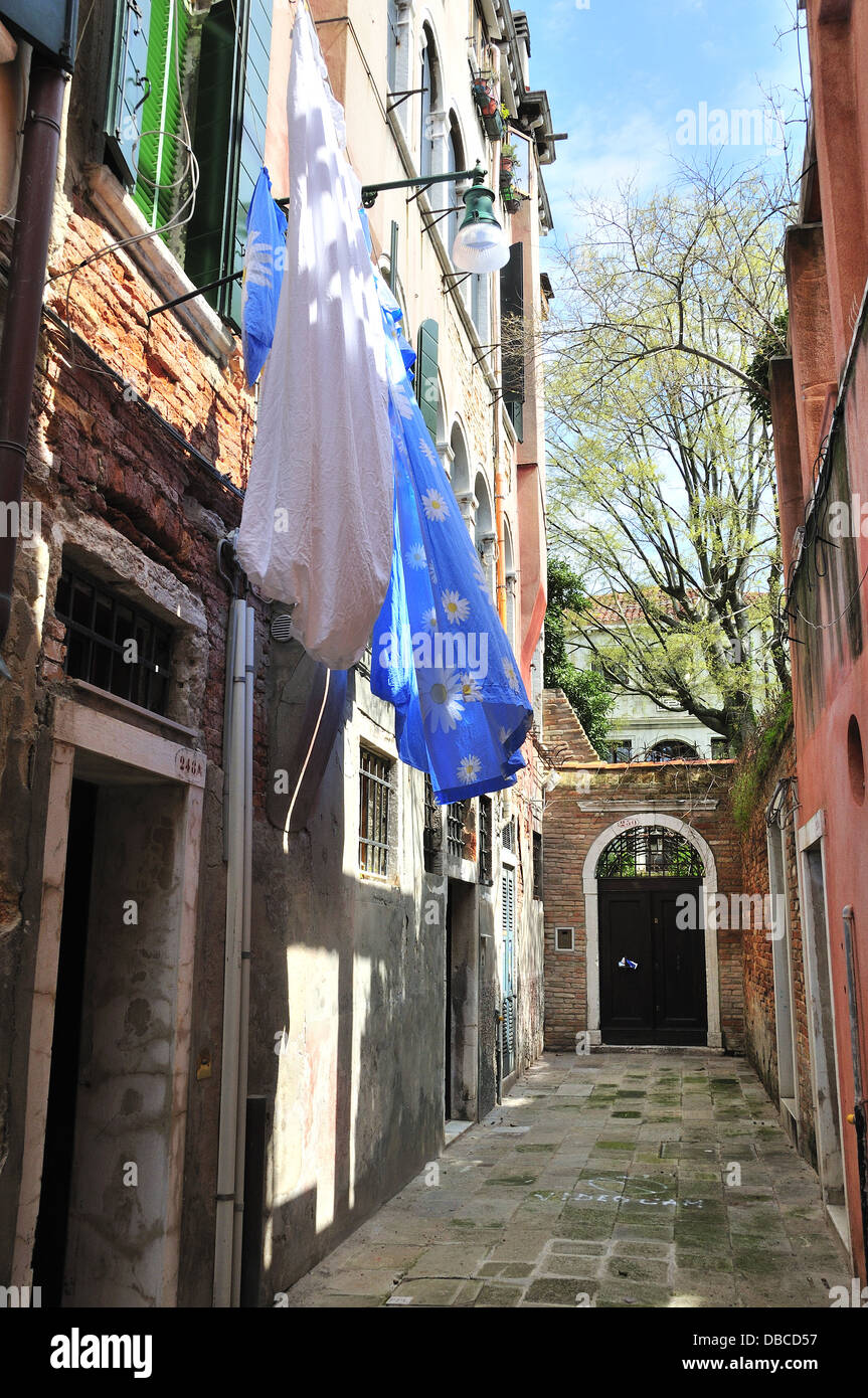 Kleine Hinterstraße mit blauen Laken hingen an sonnigen Tagen draußen Häuser in Venedig, Venedig, Venetien, Italien, Europa zu trocknen Stockfoto