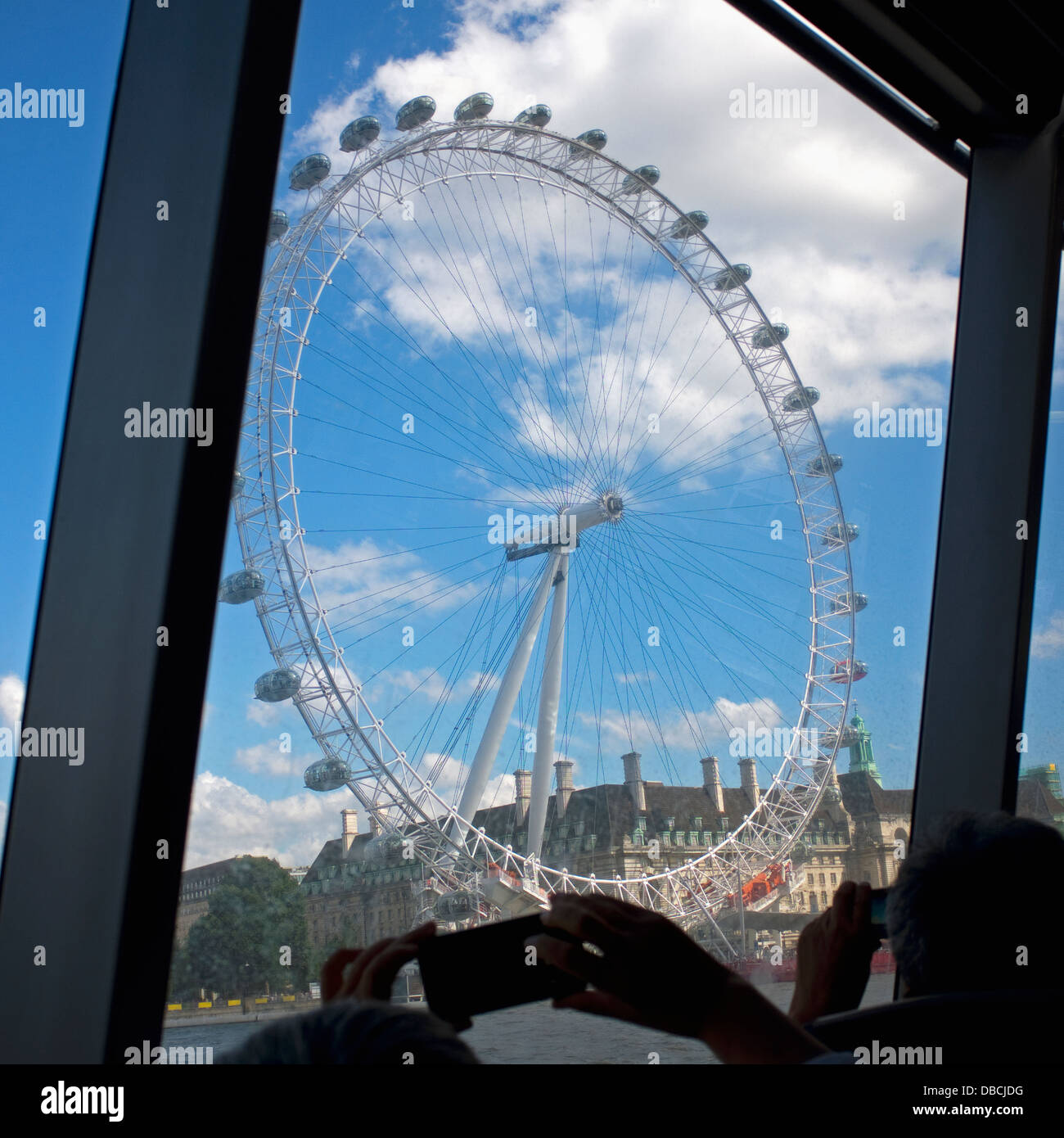 Touristen fotografieren The London Eye von einem Boot auf der Themse. Stockfoto