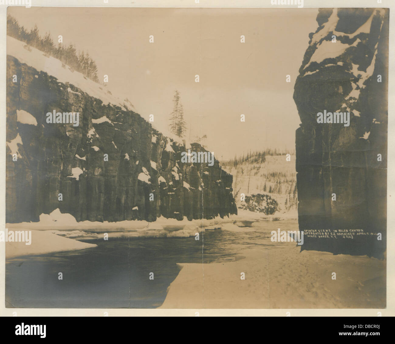 Eine Winterszene, die die gefrorene Landschaft des Miles Canyon zeigt und die raue Schönheit der Gegend in einem historischen Kontext zeigt. Stockfoto